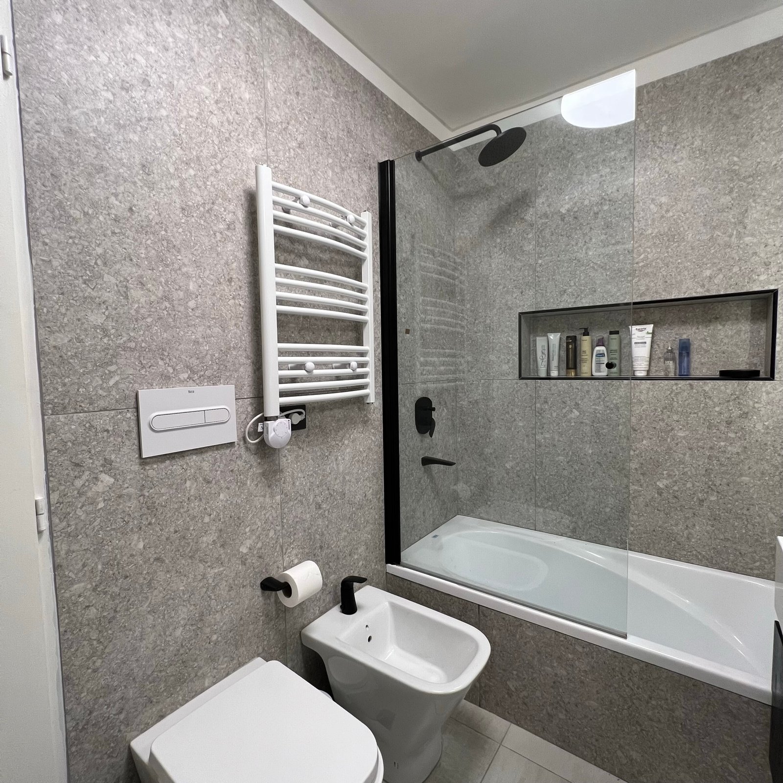 baño moderno con ducha y bañera exenta, paredes grises texturizadas — proyecto Cranwell, por MDBK Arquitectura, en Flores