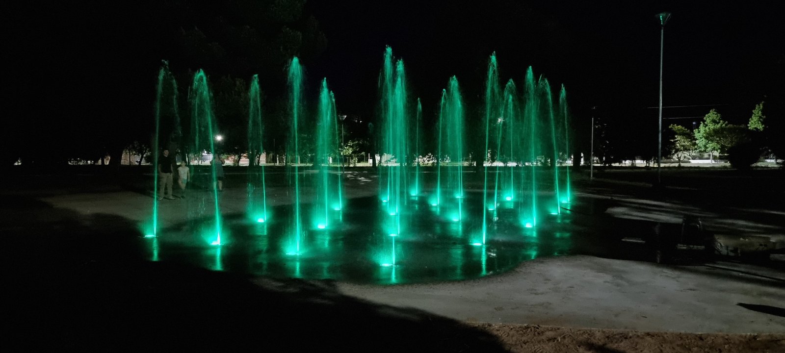 fonte pública iluminada com jatos verdes neon — projeto Fuente Plaza Seca Maisonnave, por FUENTES Y MUROS .COM.AR, em Damian Maisonave