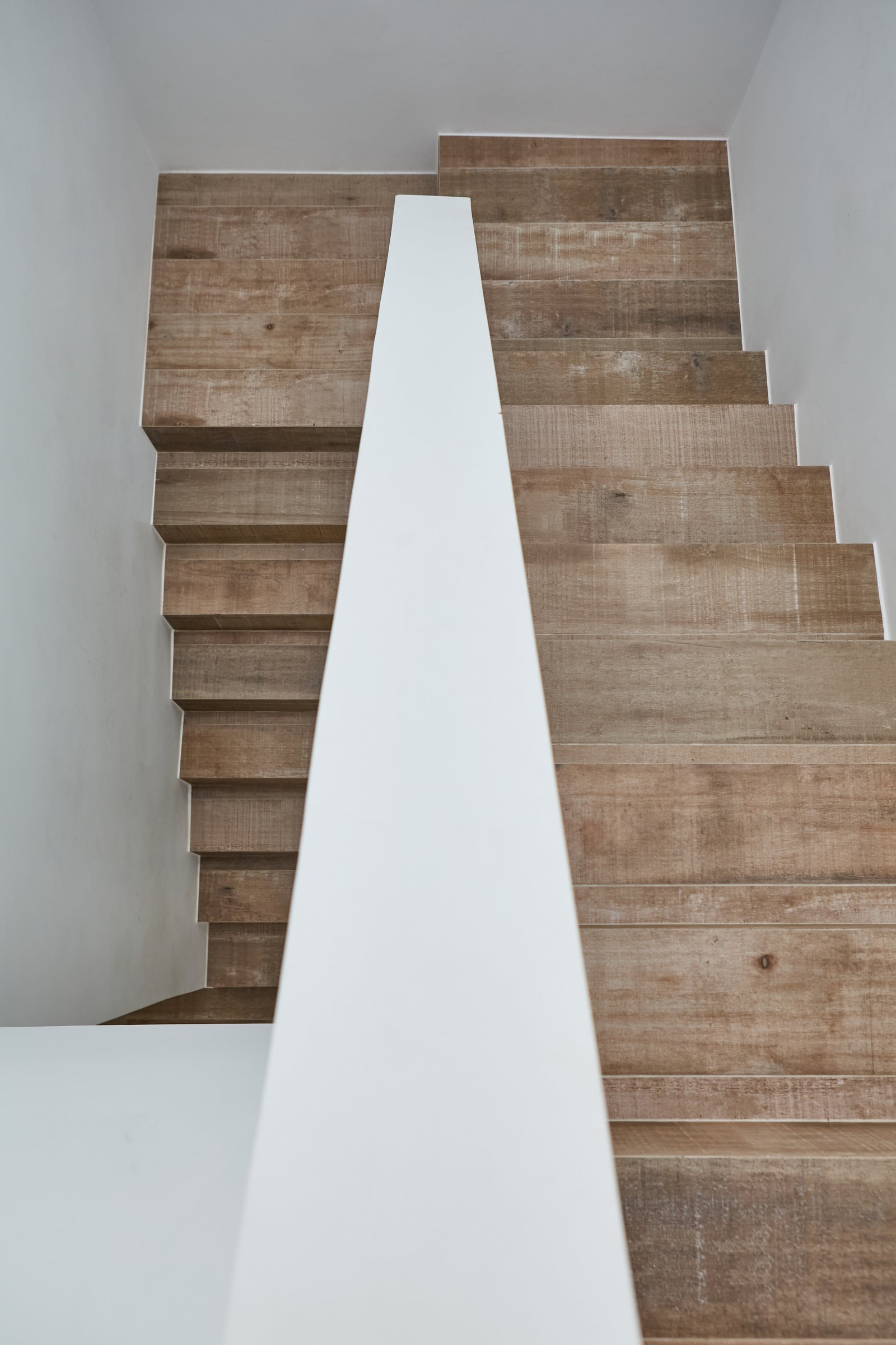 Escalera flotante moderna de madera y baranda blanca — proyecto Escalera, por CASA1-TROMEN, en Bella Vista