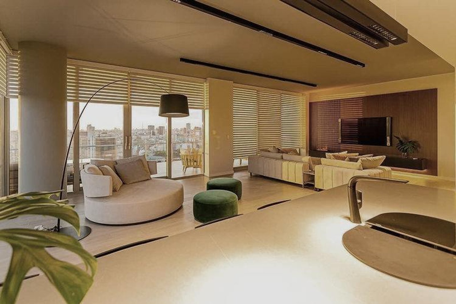 Living moderno con vistas urbanas y sofá curvo — proyecto Espacios, por BURANI, en Martínez