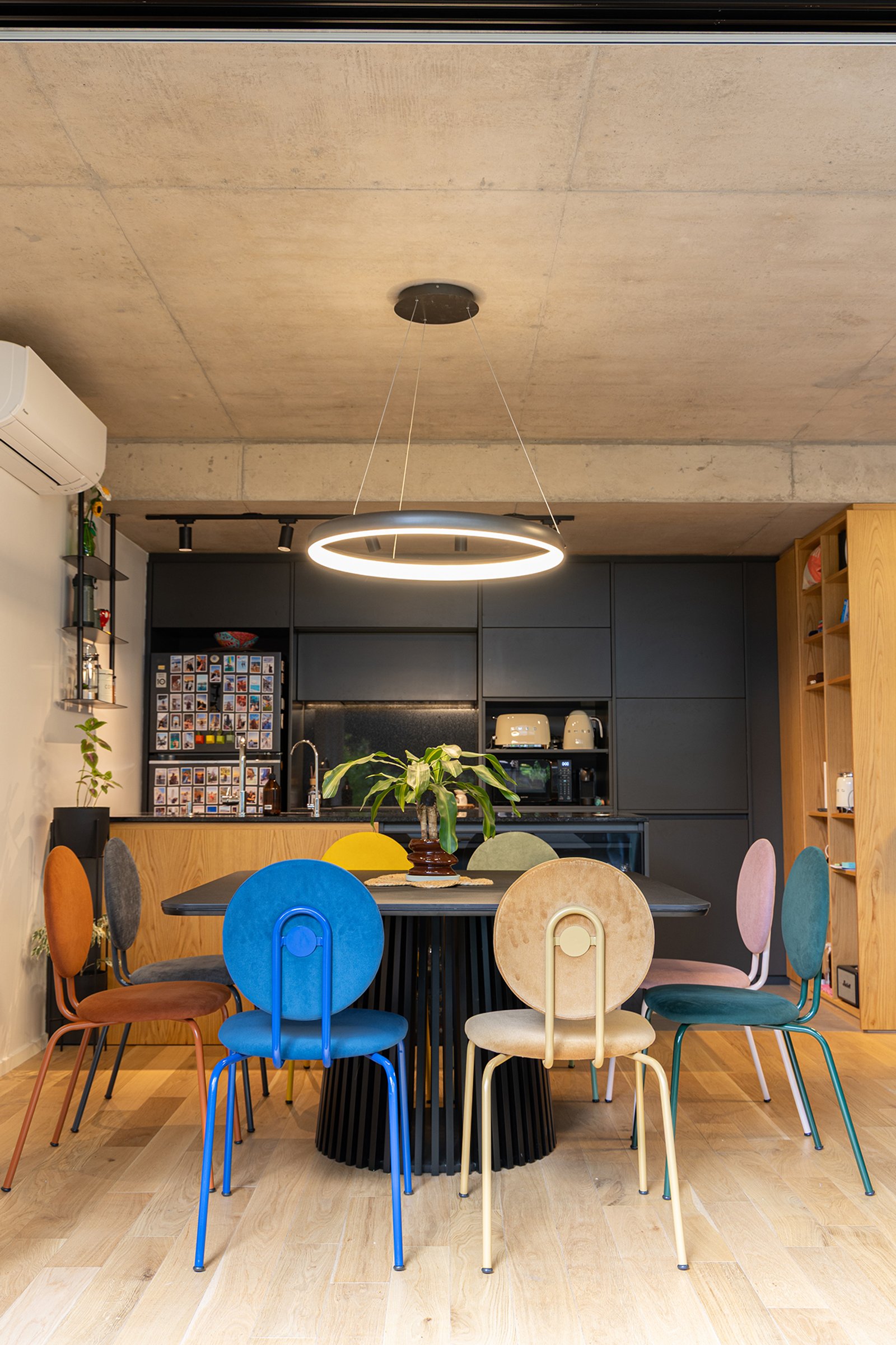 Sala de jantar moderna com cadeiras coloridas e teto de concreto — projeto THE PINK - ARQ MDBK, por Gaby Alfonso, em Palermo Soho