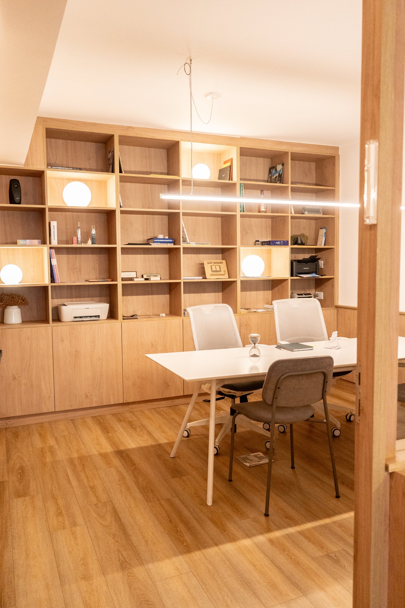 Oficina moderna con estanterías de madera y mesa de conferencias — proyecto Gorriti, por MDBK Arquitectura, en Palermo