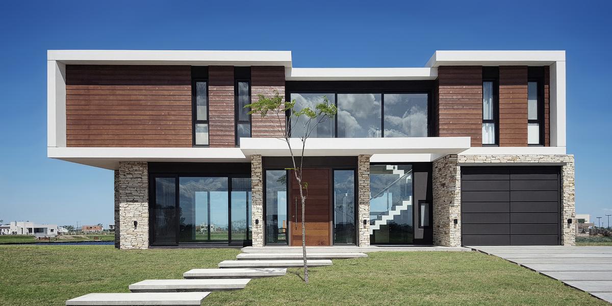 Casa moderna com revestimento de madeira e pedra, e grandes janelas — projeto CASA PUERTOS, por ABAD GADANO, em Belén de Escobar