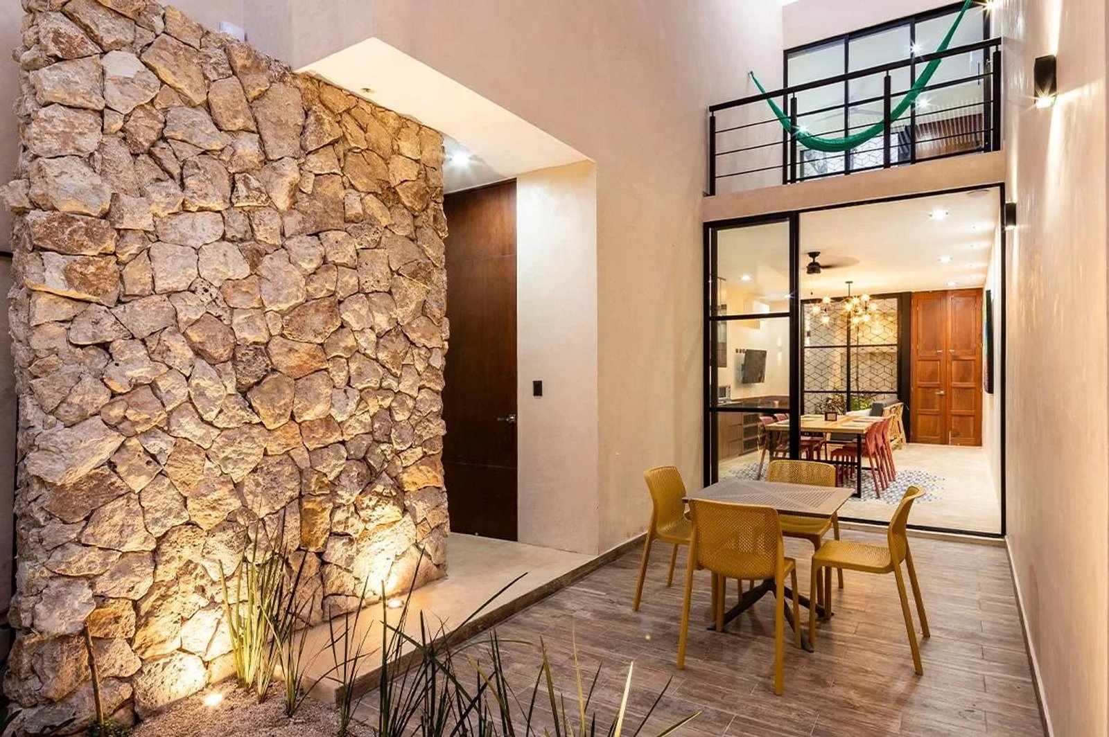 Interior rústico moderno con pared de piedra texturada y vigas de madera — proyecto Comedor, por Casa Nuñez