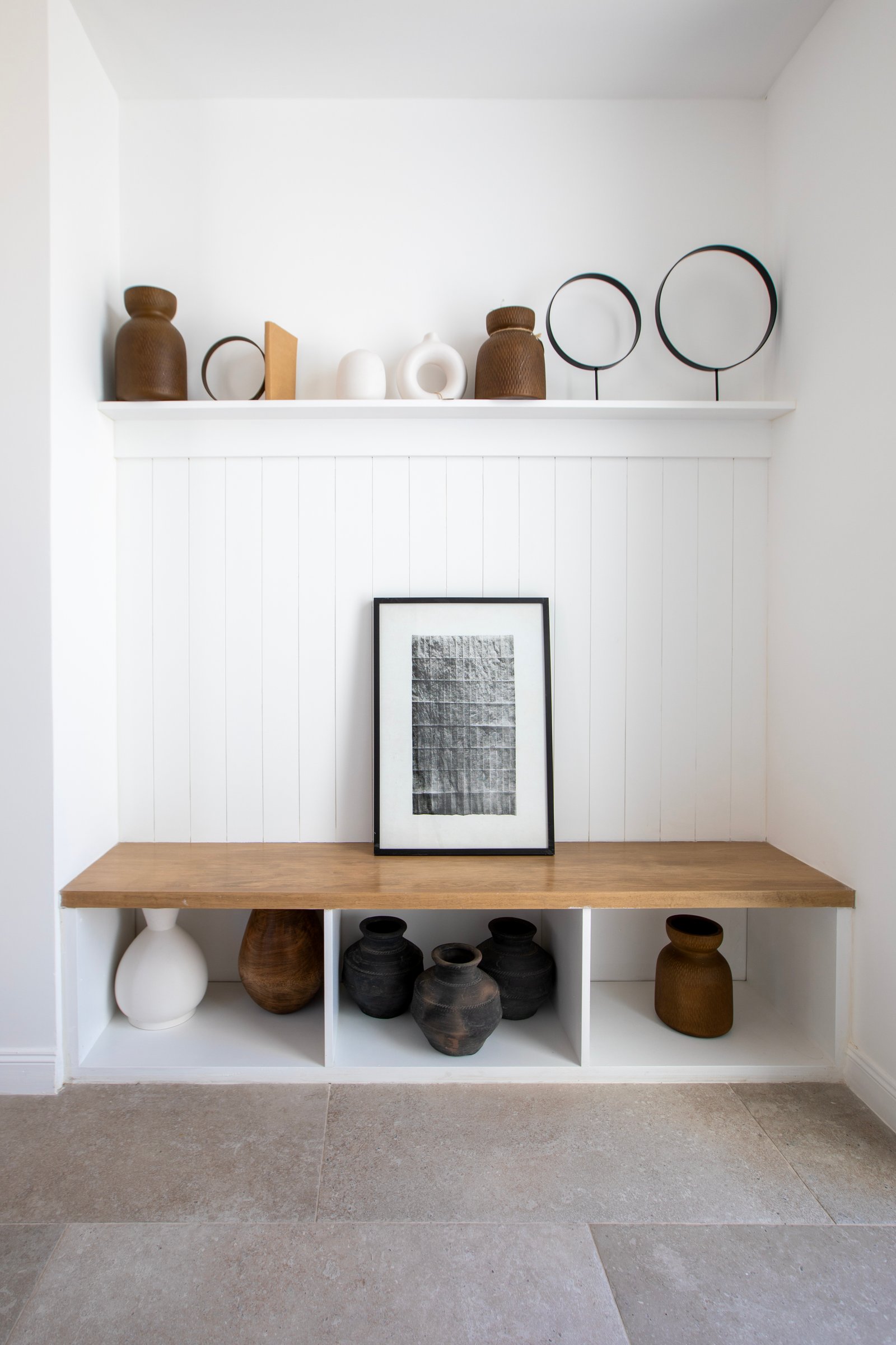 Prateleira minimalista com vasos de cerâmica e arte abstrata — projeto OBRA LE PIETRE DEL CASALE SABBIA, por ILVA, em Provincia de Buenos Aires