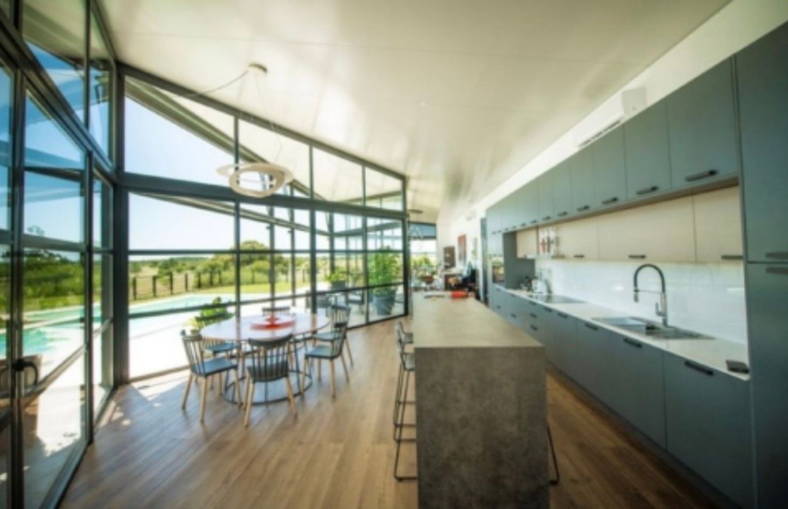 Cocina moderna con isla y vistas al exterior — proyecto B House (OMA), por ACH Architecture, en Colonia Department