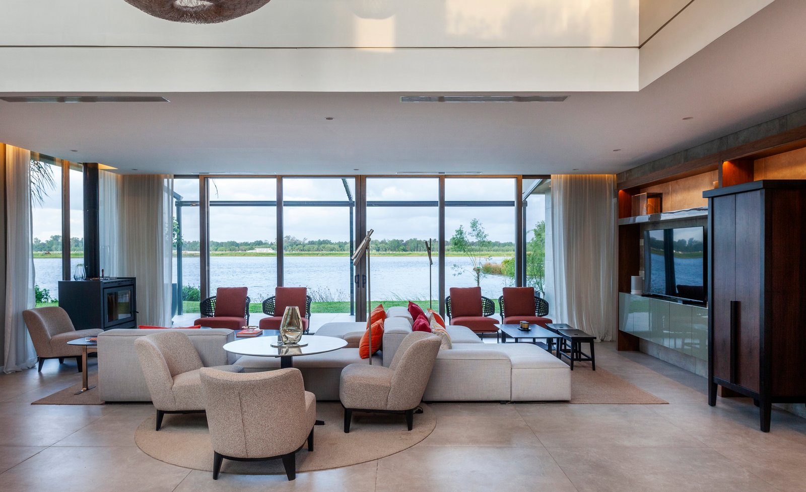 Living comedor moderno con vista al agua y muebles de diseño — proyecto CASA M40, por A'PRIMA - Arquitectura Sustentable, en Unnamed Road
