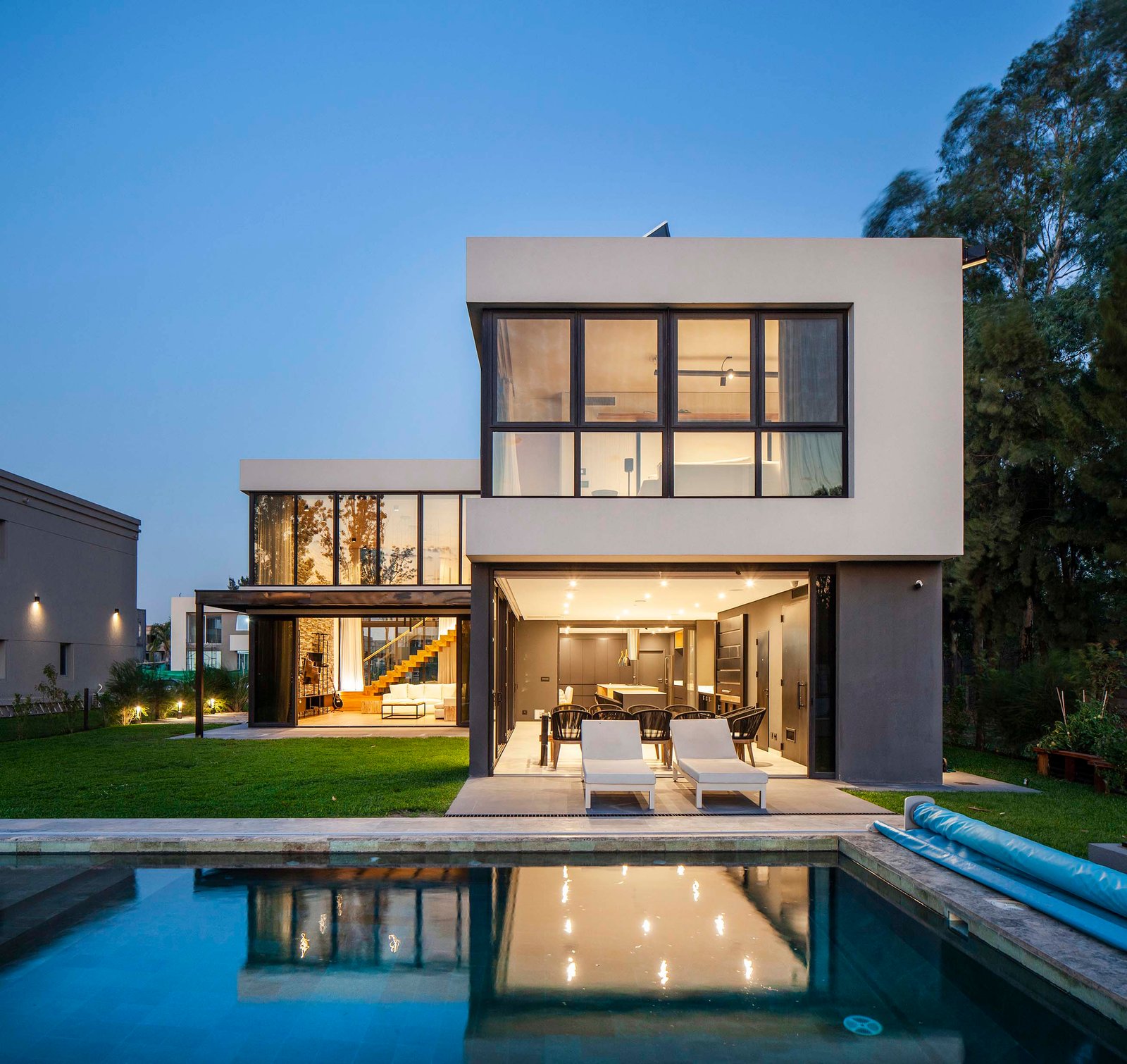 Fachada moderna con amplios ventanales y detalles en concreto — proyecto CASA T199, por A'PRIMA - Arquitectura Sustentable, en Los Robles 5901