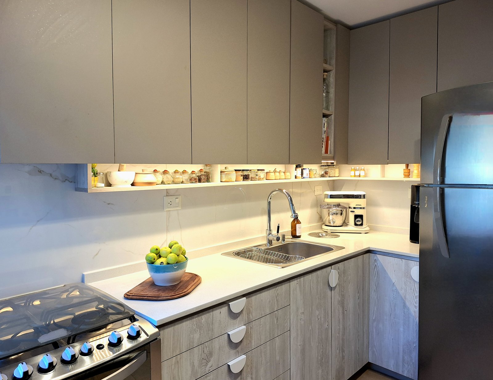 Cocina moderna gris con mesada de piedra y electrodomésticos de acero inoxidable — proyecto PROYECTO PORTEZUELO, por HALESA ESTUDIO, en Av. de los Lagos 6595