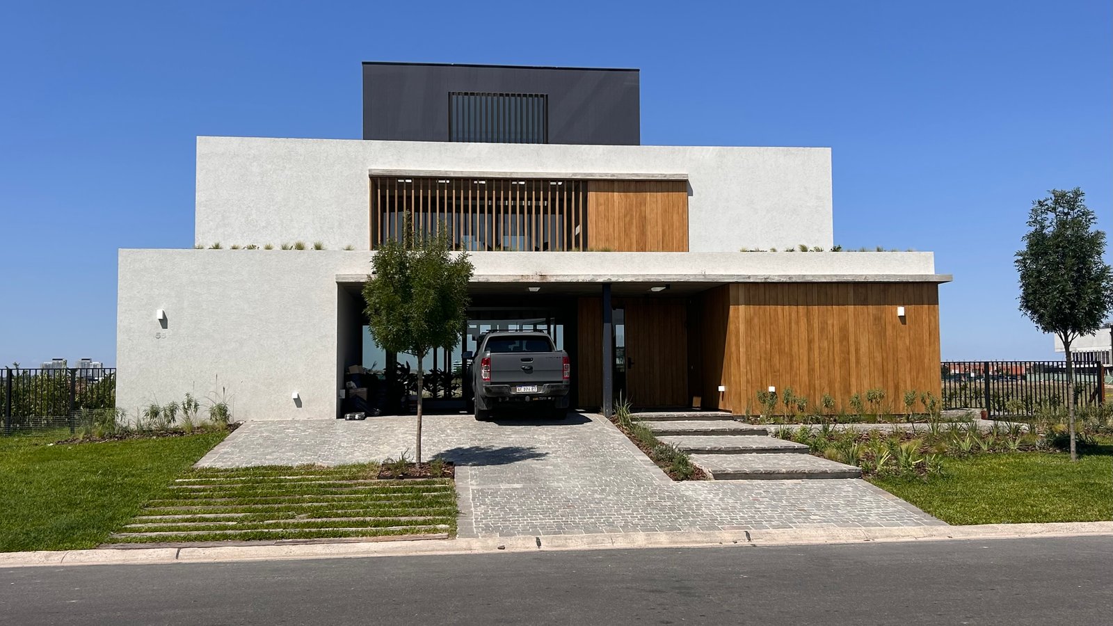fachada moderna minimalista con detalles en madera — proyecto Casa Puentes, por Guerrero Arquitectos, en Rincón de Milberg