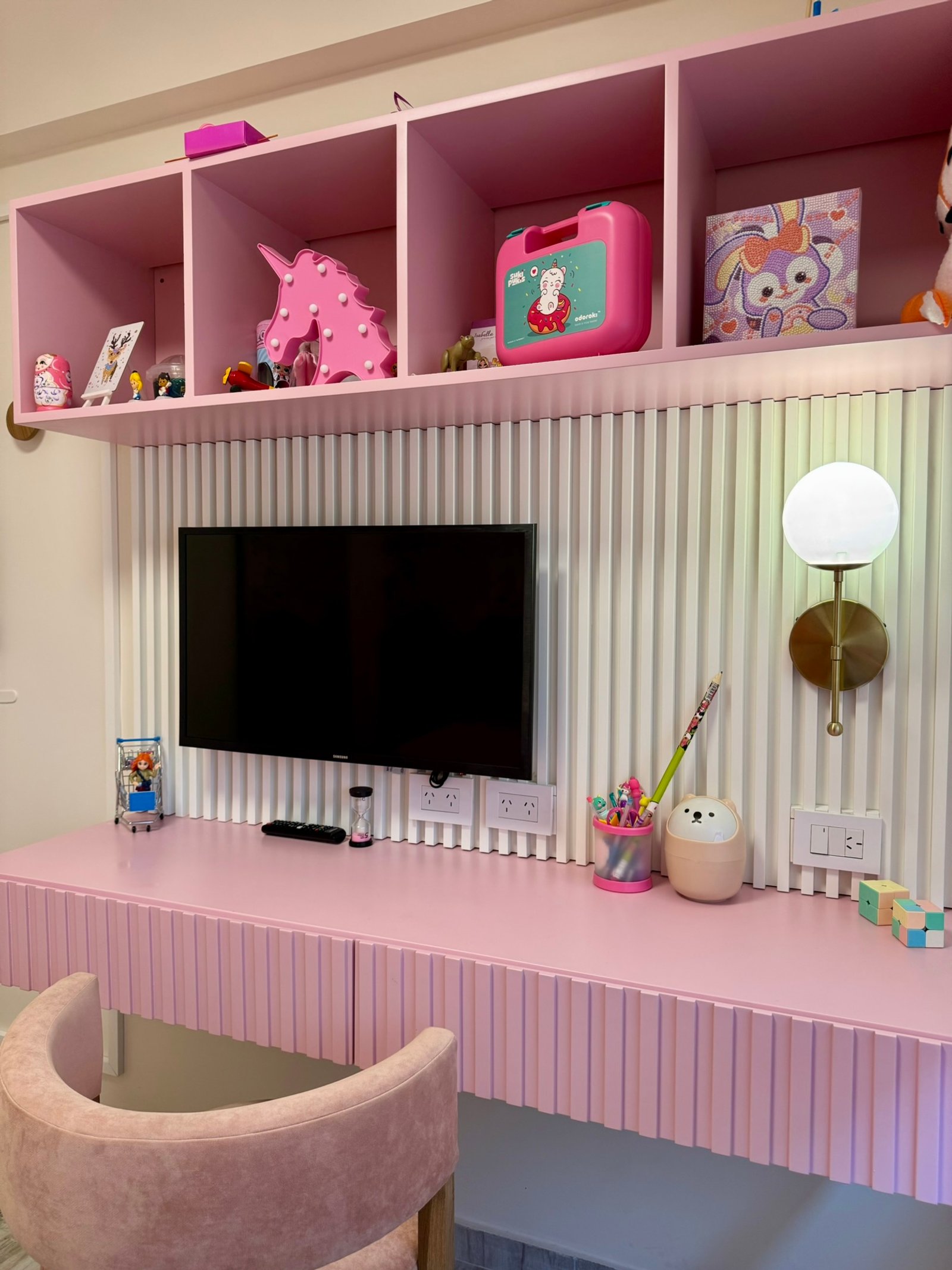 Escritorio y estanterías rosas en dormitorio infantil con decoración unicornio — proyecto Corrientes I, por MDBK Arquitectura, en Villa Crespo
