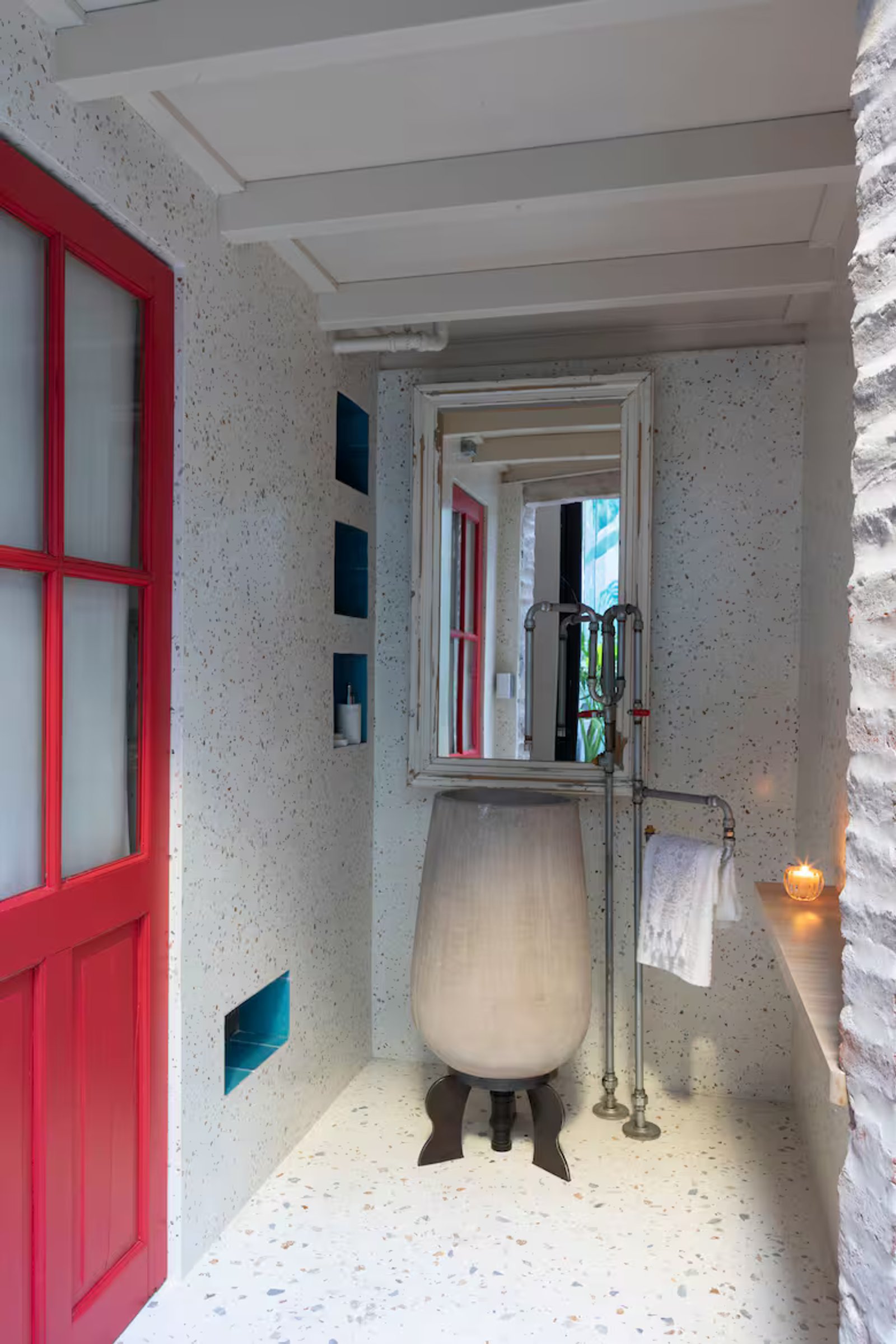 Baño moderno con puerta roja y lavabo de piedra — proyecto Casa Arcos, por Silvia Soqueff, en Núñez