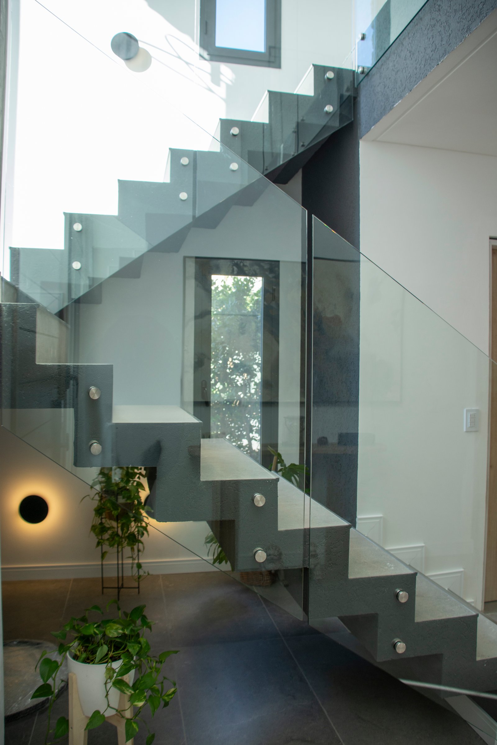 Escalera flotante moderna con peldaños de vidrio e iluminación indirecta — proyecto Casa Tipas, por MSMC, en Сармьенто 3830