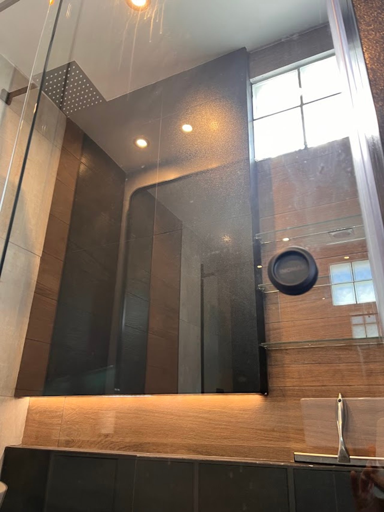 Banheiro moderno com paredes de pedra texturizada e iluminação indireta — projeto Baño, por HEIM ARQUITECTURA INTERIOR, em Caballito