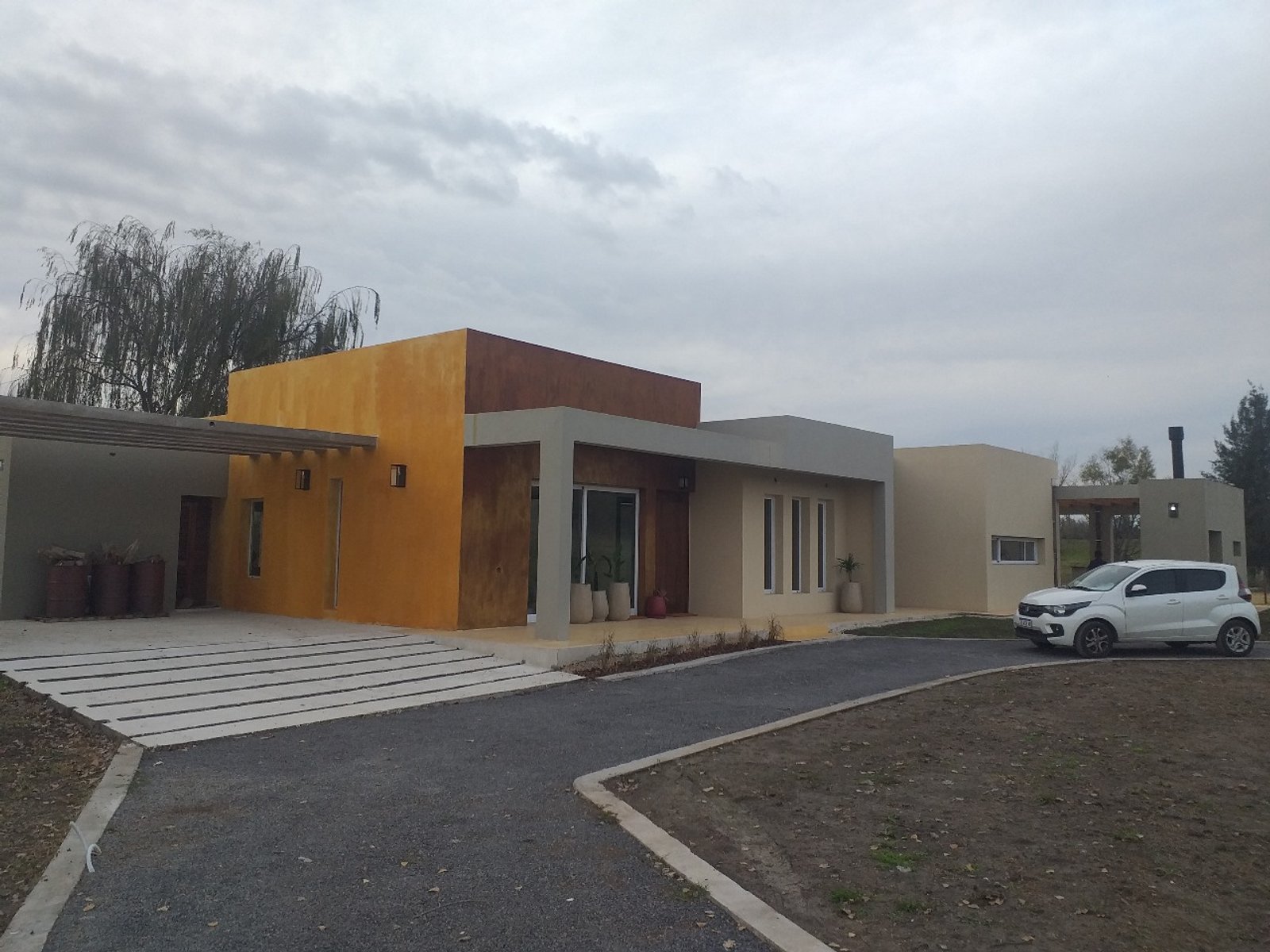 Casa moderna de volúmenes asimétricos con fachada de hormigón visto — proyecto Vivienda unifamiliar en Chacras de la reserva , por Sep Arquitectura , en B2814 Los Cardales