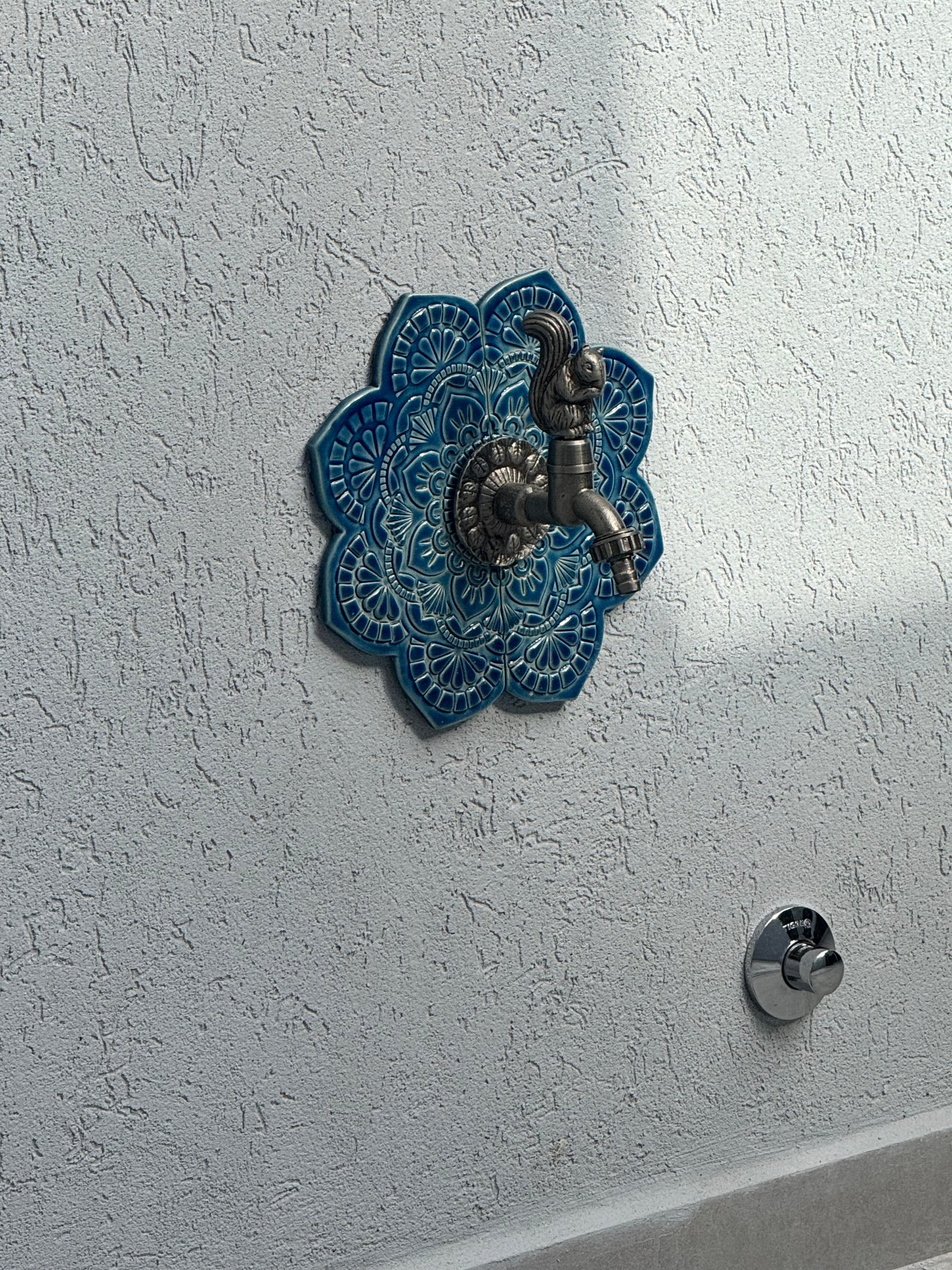 Torneira antiga de metal sobre azulejo azul decorativo — projeto CASA M, por Estudio Grupo 32, em Martínez