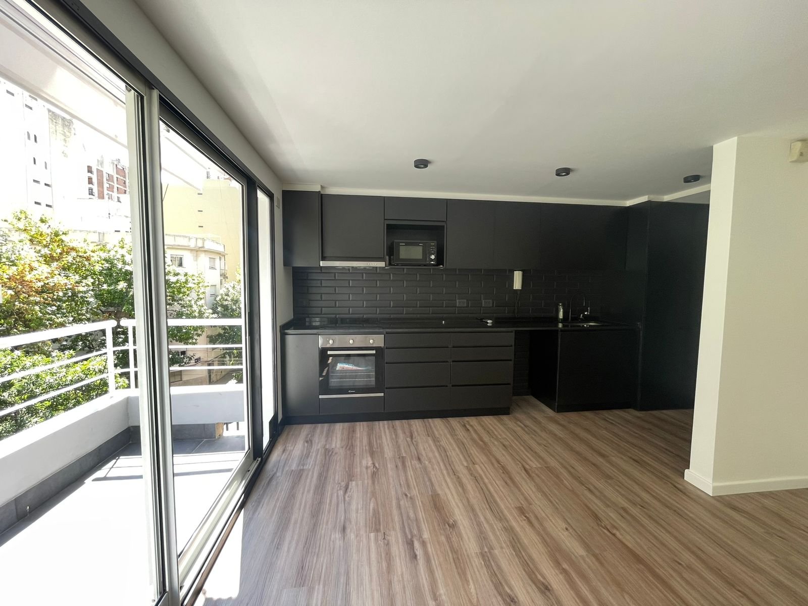 Cocina moderna con isla, ventanales amplios y piso de madera — proyecto Jorge Newbery , por Estudio NET Arquitectura , en Av. Jorge Newbery 1820