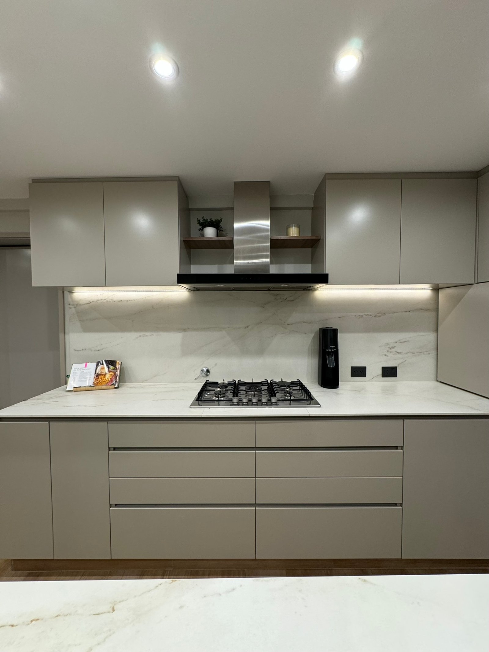 Cocina moderna minimalista con muebles beige, mesada y salpicadero de mármol — proyecto Las Heras, por MDBK Arquitectura, en Palermo