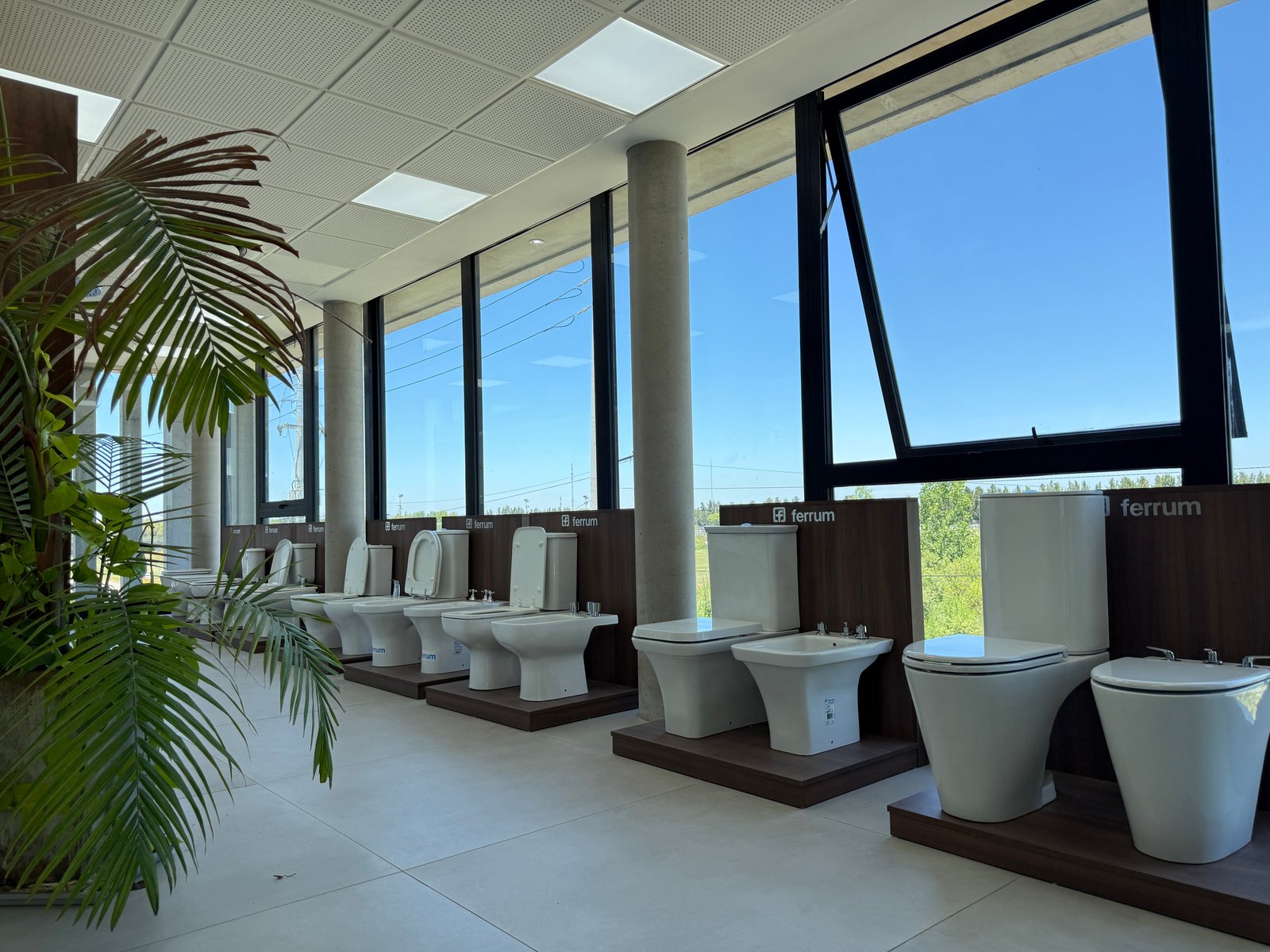 Sala de exposición de baños modernos con inodoros y ventanas grandes — proyecto Showroom, por GAP HAUS, en Calle Austria Nte. 2450