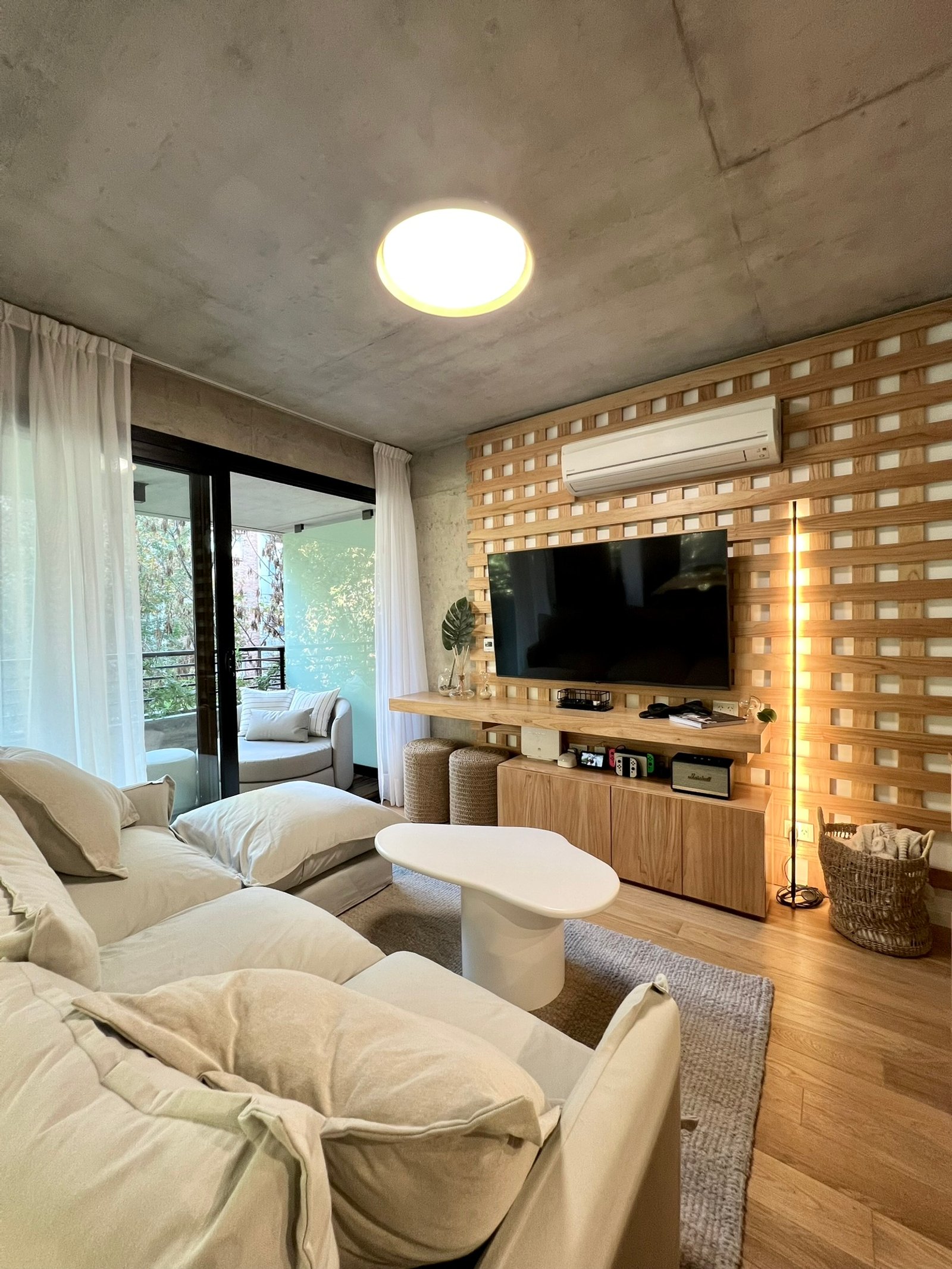Sala de estar moderna com parede de ripas de madeira e sofá modular — projeto Guatemala, por MDBK Arquitectura, em Palermo