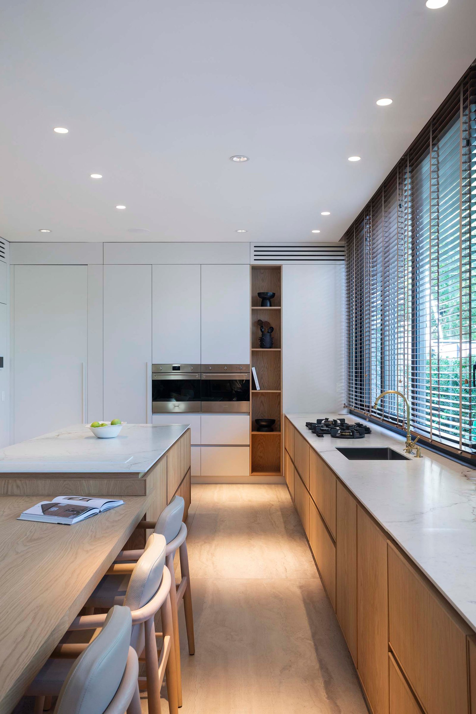 Cozinha moderna conceito aberto com ilha e armários de madeira — projeto Casa Magnolia, por Estudio PK, em San Isidro