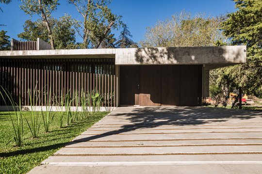 Fachada moderna con listones de madera verticales y hormigón — proyecto Casa Arq César Cassolino, por MUCHTEK, en La Plata