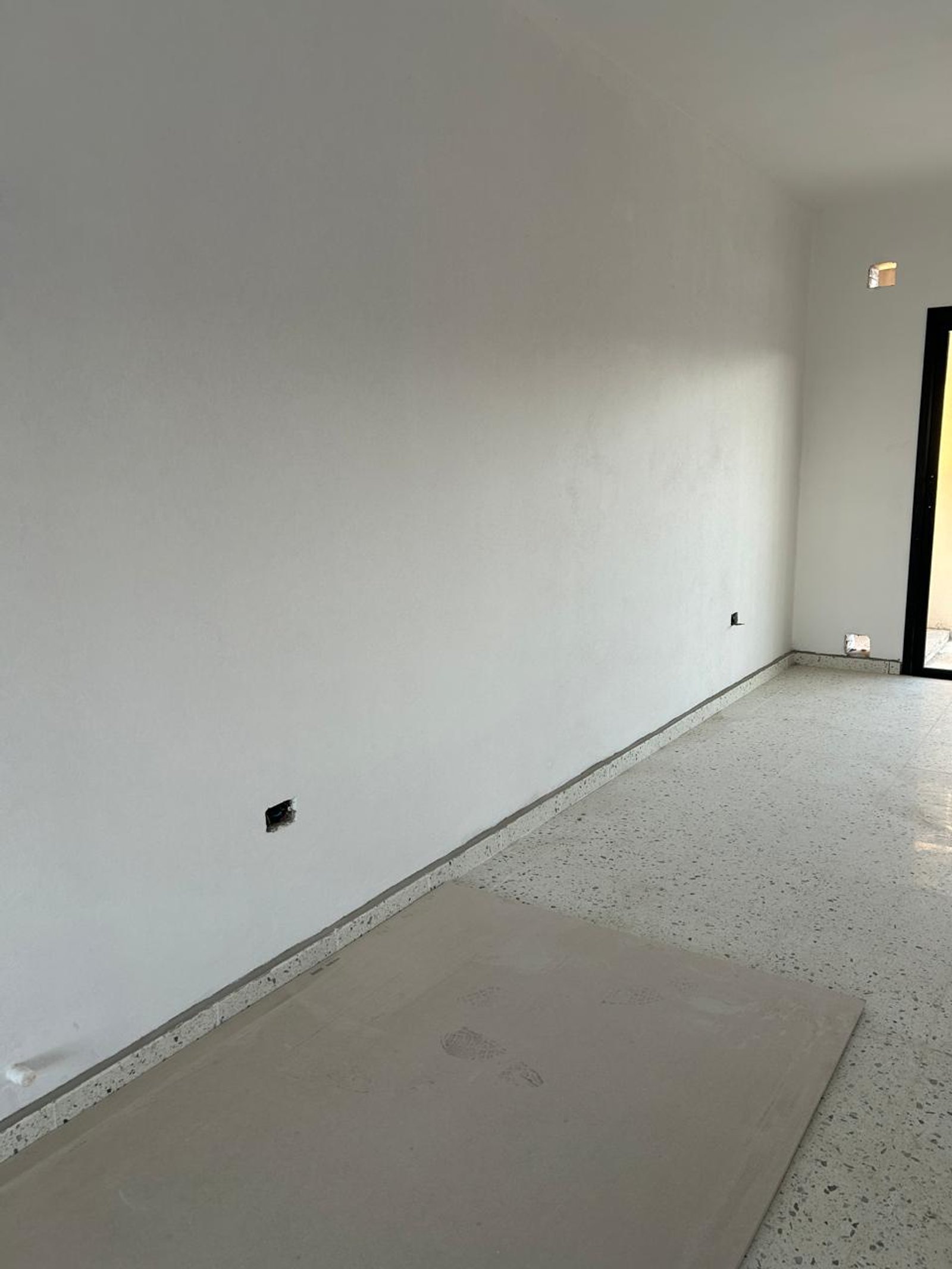 interior en construcción con pared blanca y piso de terrazo — proyecto PROYECTO MJC, por Todo con A, en X5125 Monte Cristo