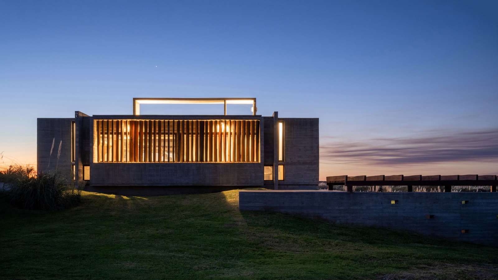 Modern casa costera con fachada de hormigón y madera — proyecto Casa Médanos, por Besonías Almeida arquitectos, en JWRC+MQ