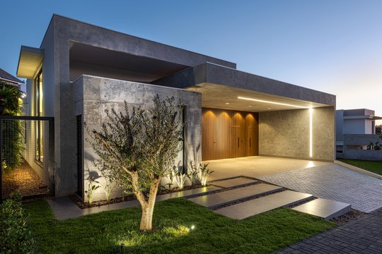 fachada moderna con luces integradas y árbol — proyecto Residência Lago, por Paulo Lopes Arquitetura, en Maringá