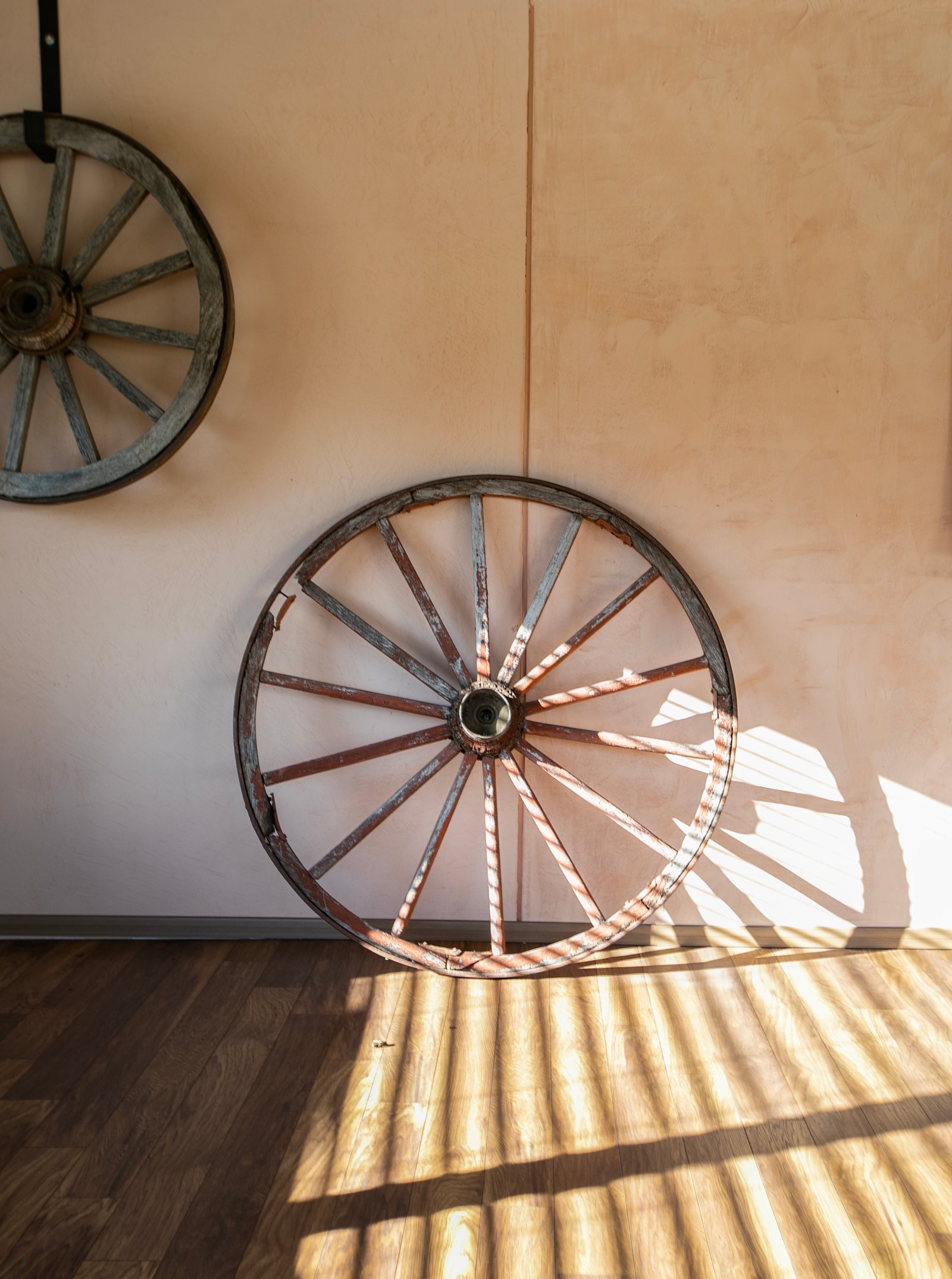 duas rodas de carroça rústicas decorando parede — projeto Barreto, por Estudio Losa, em Palermo