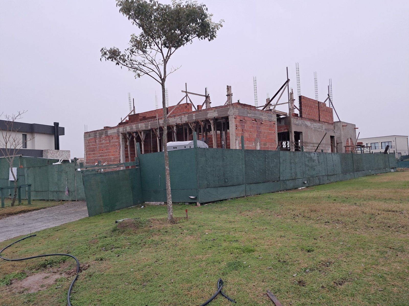 casa em construcao com cerca verde — projeto RIBERAS  332, por IRALA CONSTRUCCIONES, em Belén de Escobar