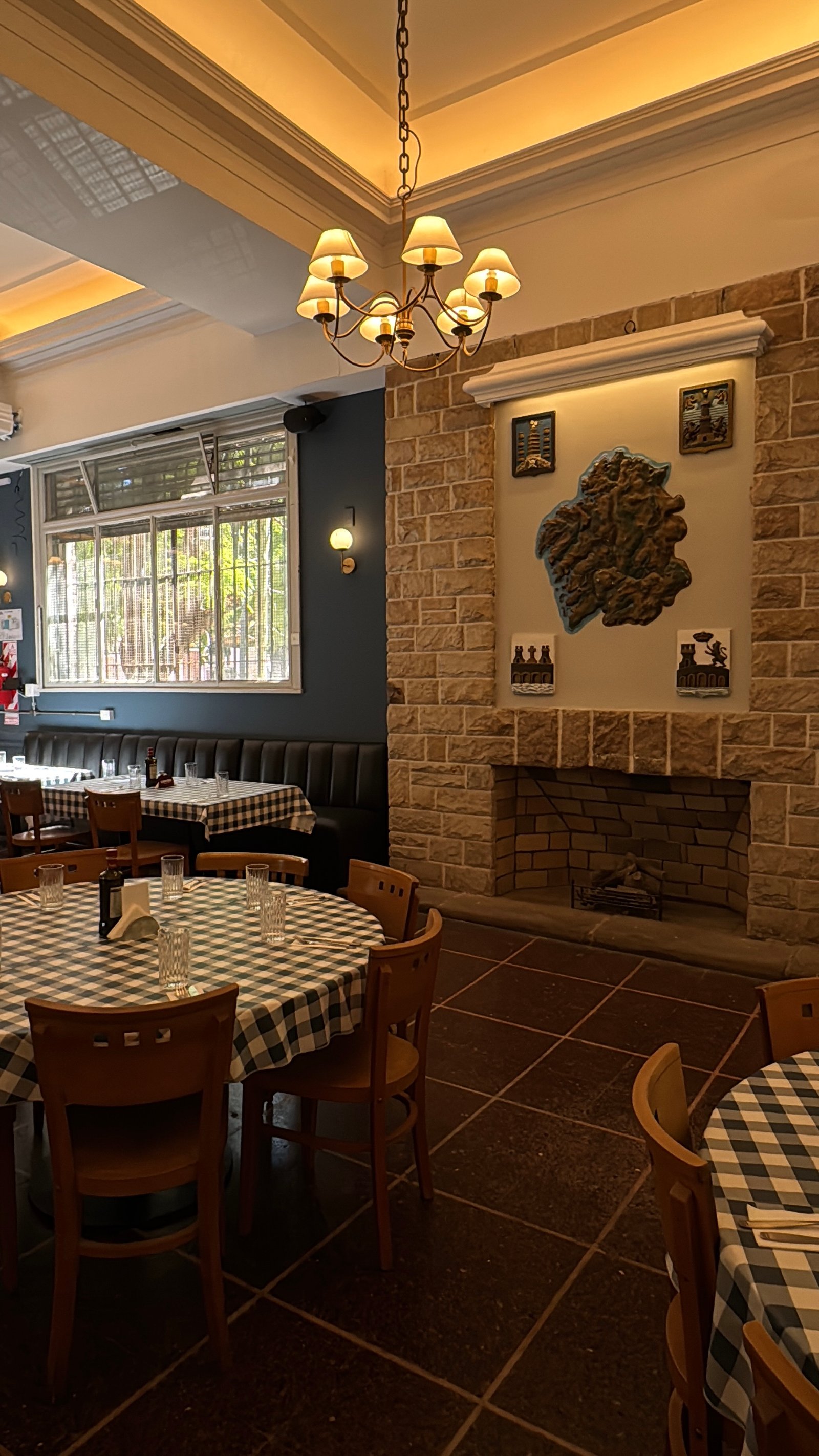 Comedor de restaurante rústico con chimenea de piedra y mesas a cuadros — proyecto Galicia restaurante , por Remodela tu local , en Retiro