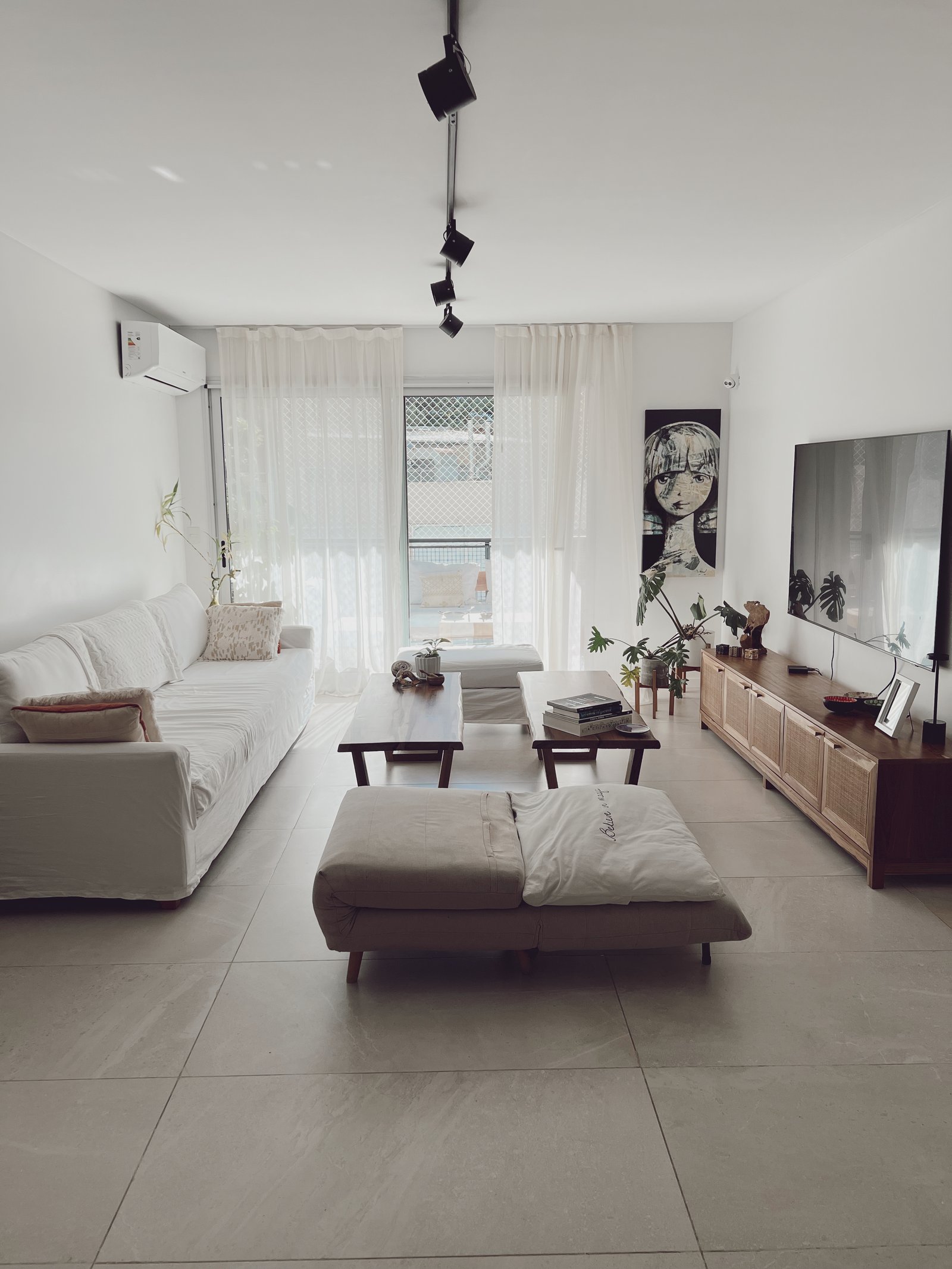 Living moderno escandinavo con sofá blanco y suelo de piedra — proyecto Libertador, por Equipe, en Buenos Aires