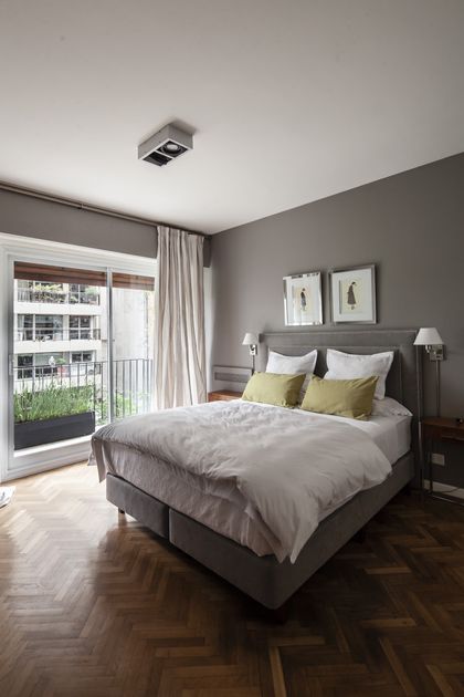 Dormitorio gris contemporáneo con cama tapizada y ventanal a terraza — proyecto GO2219, por Facundo Arana Arquitecto