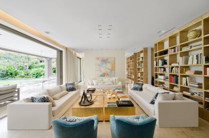 Living moderno con ventanales, estanterías y sofás claros — proyecto Casa H, por Estudio Dado, en Belgrano