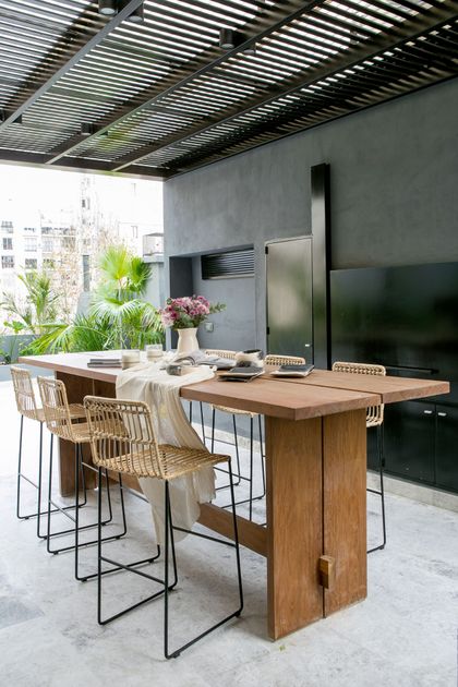comedor exterior moderno con mesa de madera y sillas de ratán — proyecto BA 2 2019, por Mesopotamia Ba, en CABA