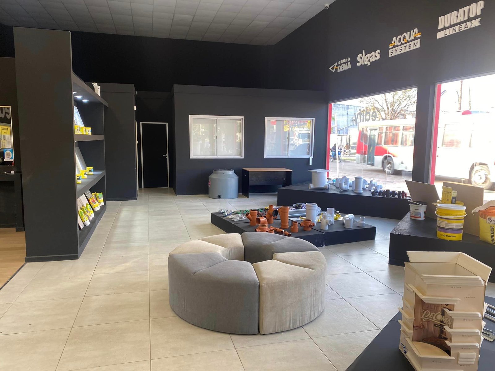 Local comercial moderno con exhibidores y sofá circular — proyecto Edify Corrientes, Casa de Materiales de Construccion., por Arquitecto Gustavo Maidana, en Corrientes