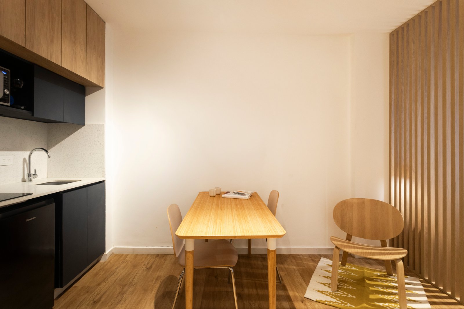 Comedor escandinavo con cocina minimalista integrada y pared de listones de madera — proyecto REFORMA NE, por Rastro Estudio, en Palermo