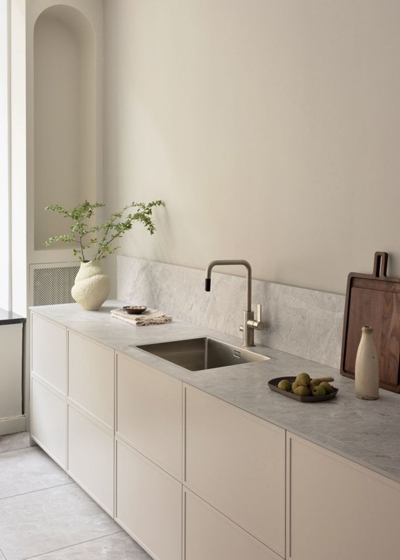 Cocina minimalista con gabinetes beige, mesada y salpicadero de mármol gris — proyecto Línea Malaga, por Casa Leiro