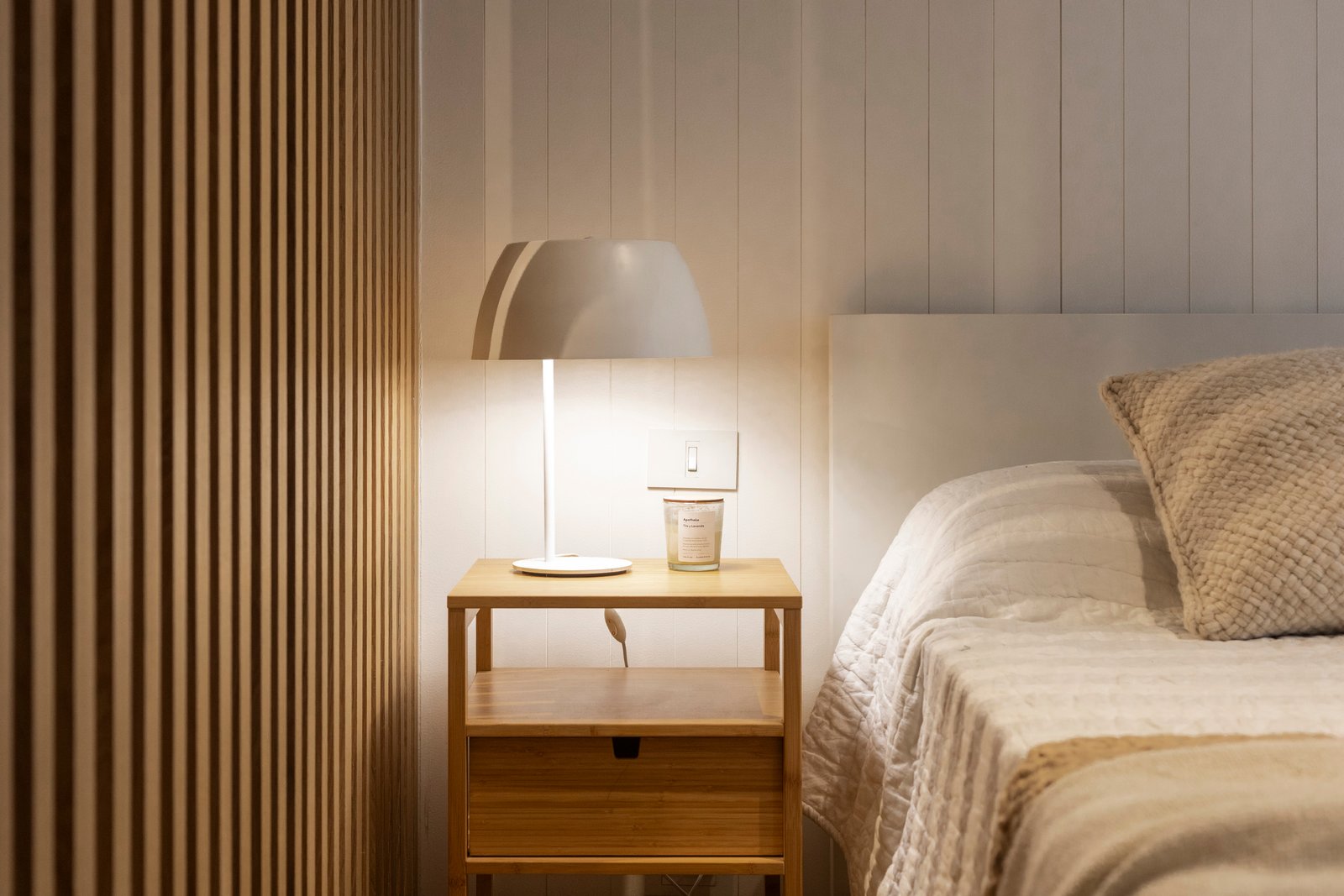 Dormitorio nórdico con pared de lamas de madera y lámpara moderna — proyecto REFORMA NE, por Rastro Estudio, en Palermo