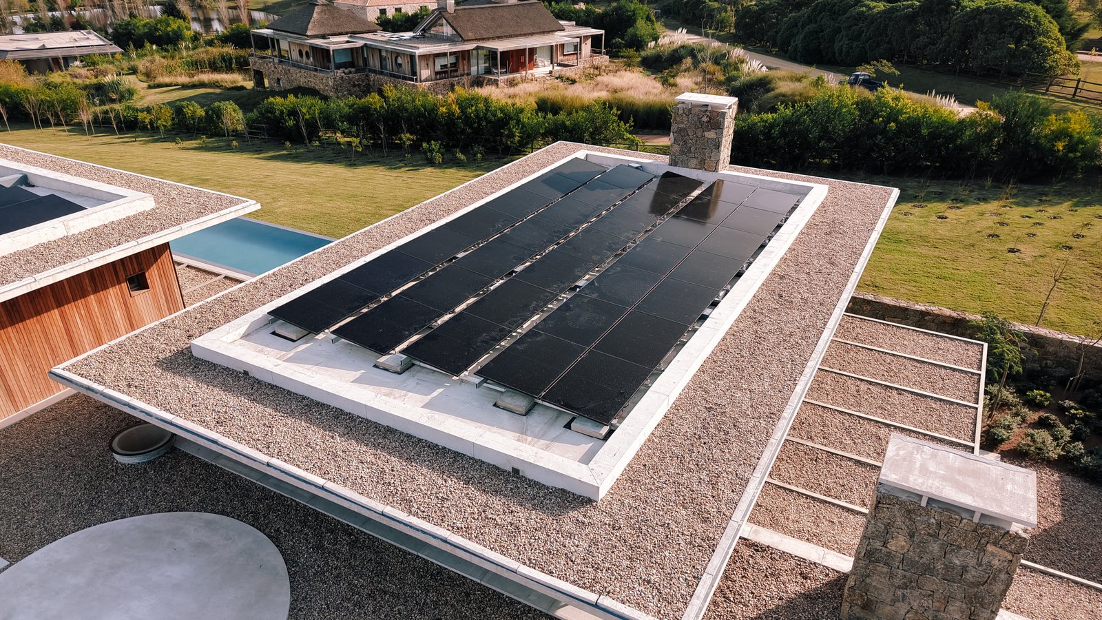 Fachada moderna con paneles solares y detalles en piedra — proyecto Laguna Estates, en Maldonado