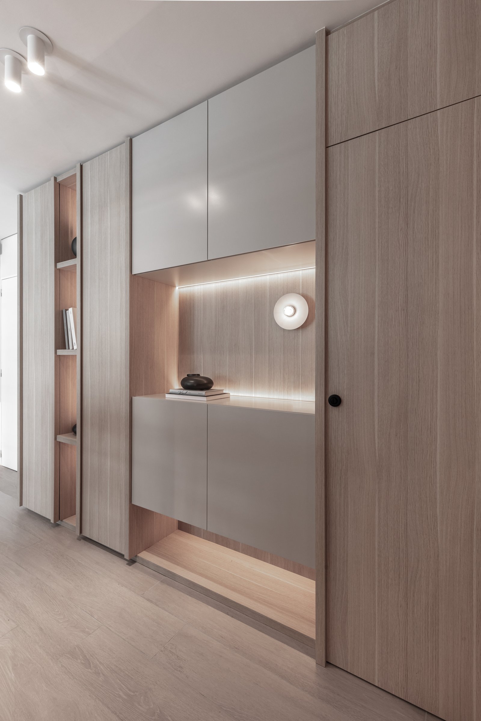 Pasillo moderno con almacenamiento de madera integrado y luz indirecta — proyecto Eslovenia | Pied-à-terre | Lucia Quinteros, por Ren Studio, en Cdad. Autónoma de Buenos Aires