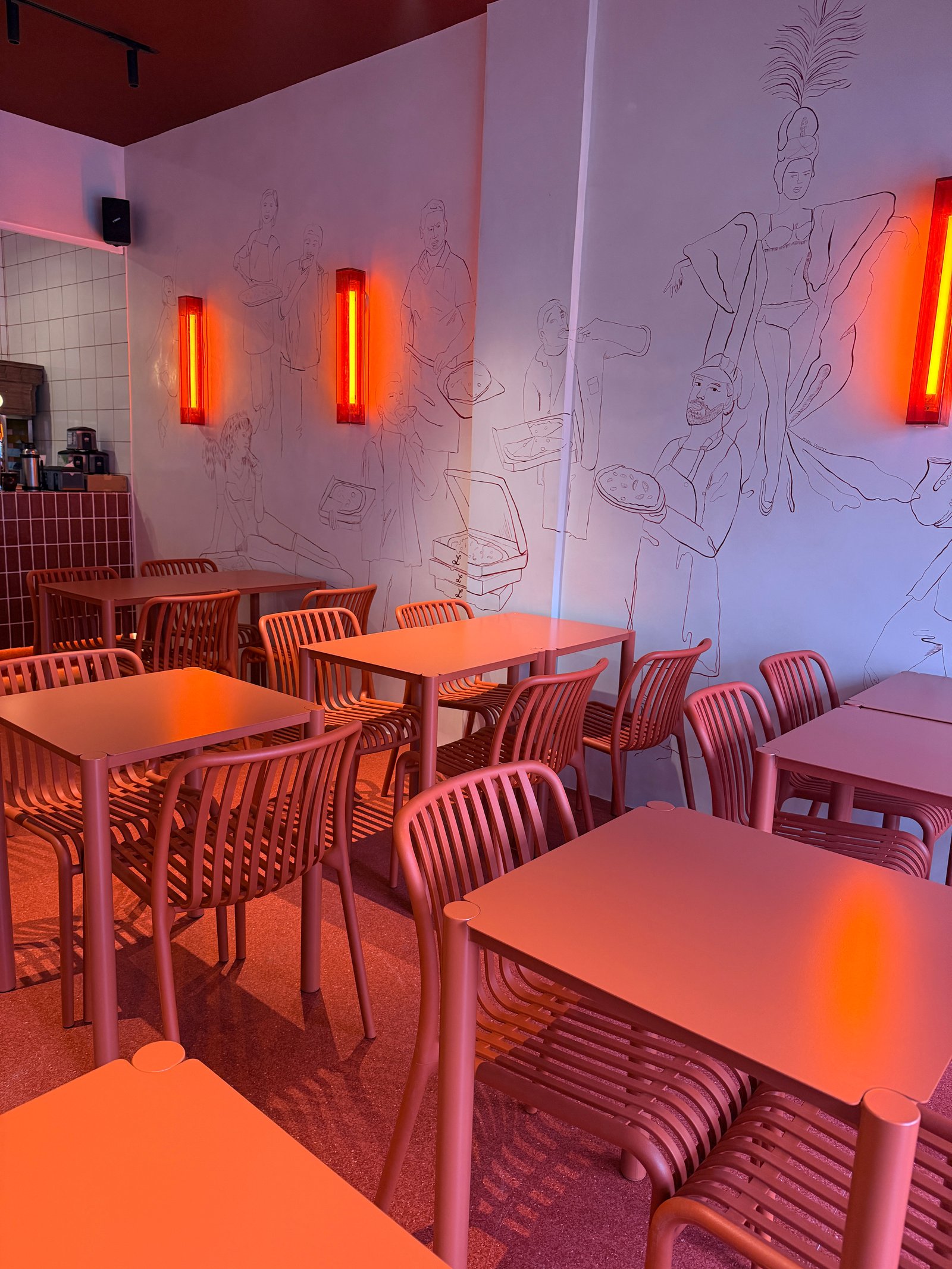 Sala de jantar moderna com mural gráfico e luzes laranjas — projeto Lunático, por Estudio Losa, em Av. Corrientes 1659