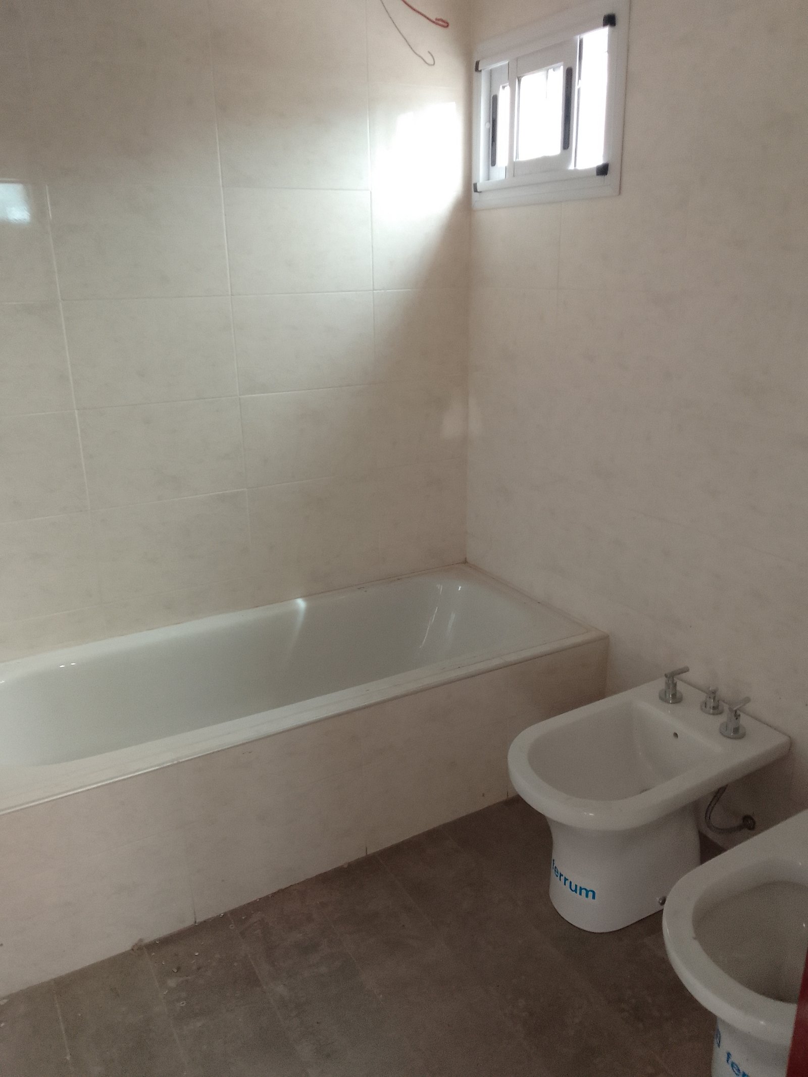 Baño con bañera blanca, bidet y ventana pequeña — proyecto 2 Casas en Lanus, por Arquitecto Guido Niccoli, en B1824 Lanús