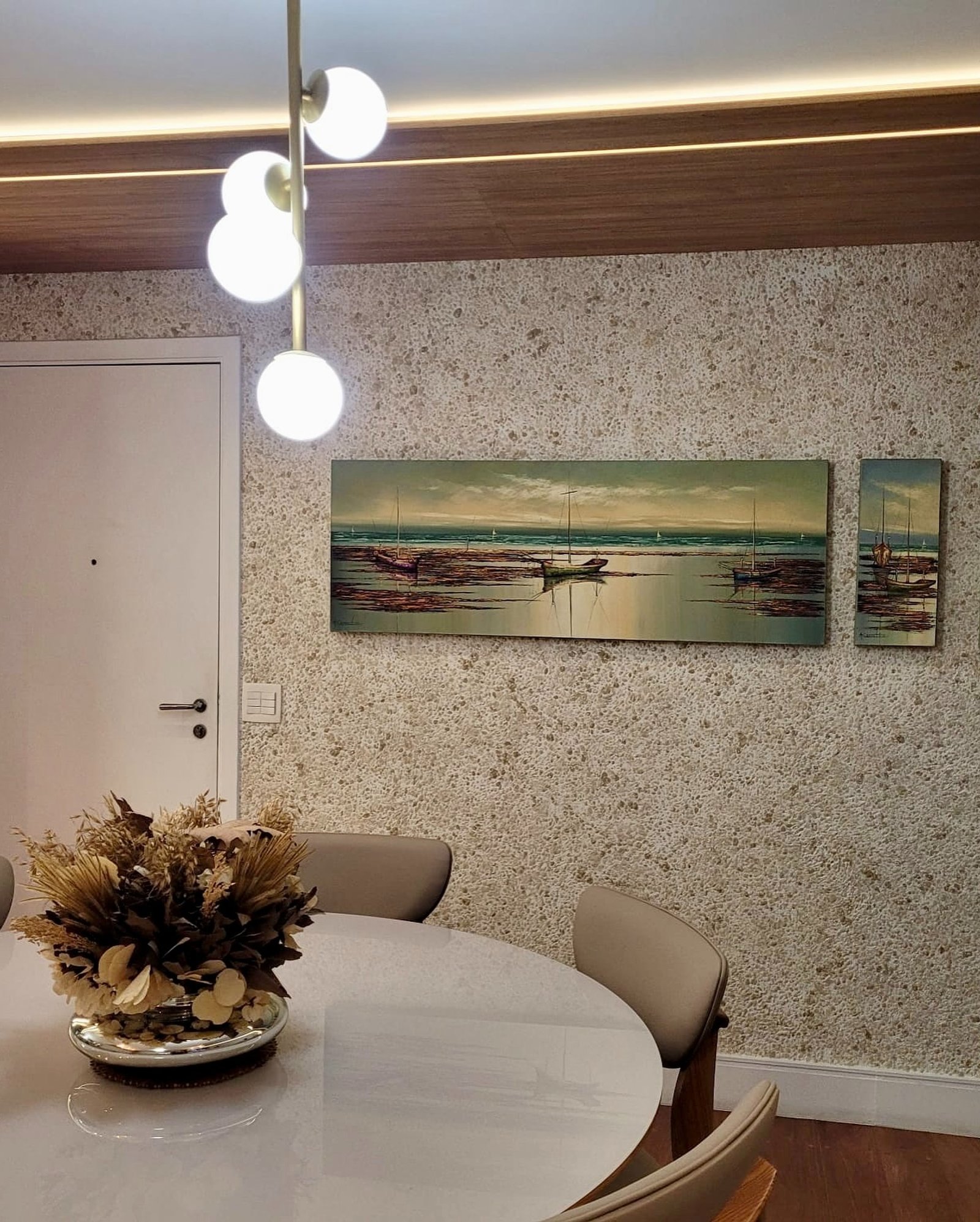 Comedor moderno con mesa redonda blanca y lámparas lineales — proyecto Comedor, por ecodecor argentina, en Buenos Aires