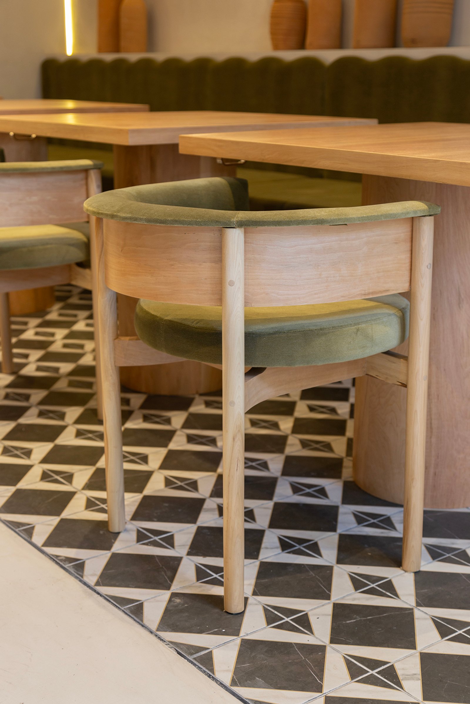 Sillas de comedor modernas con asientos curvos de terciopelo verde y suelo geométrico — proyecto HATSU Palermo - MZV Arquitectura, por Gaby Alfonso, en Palermo