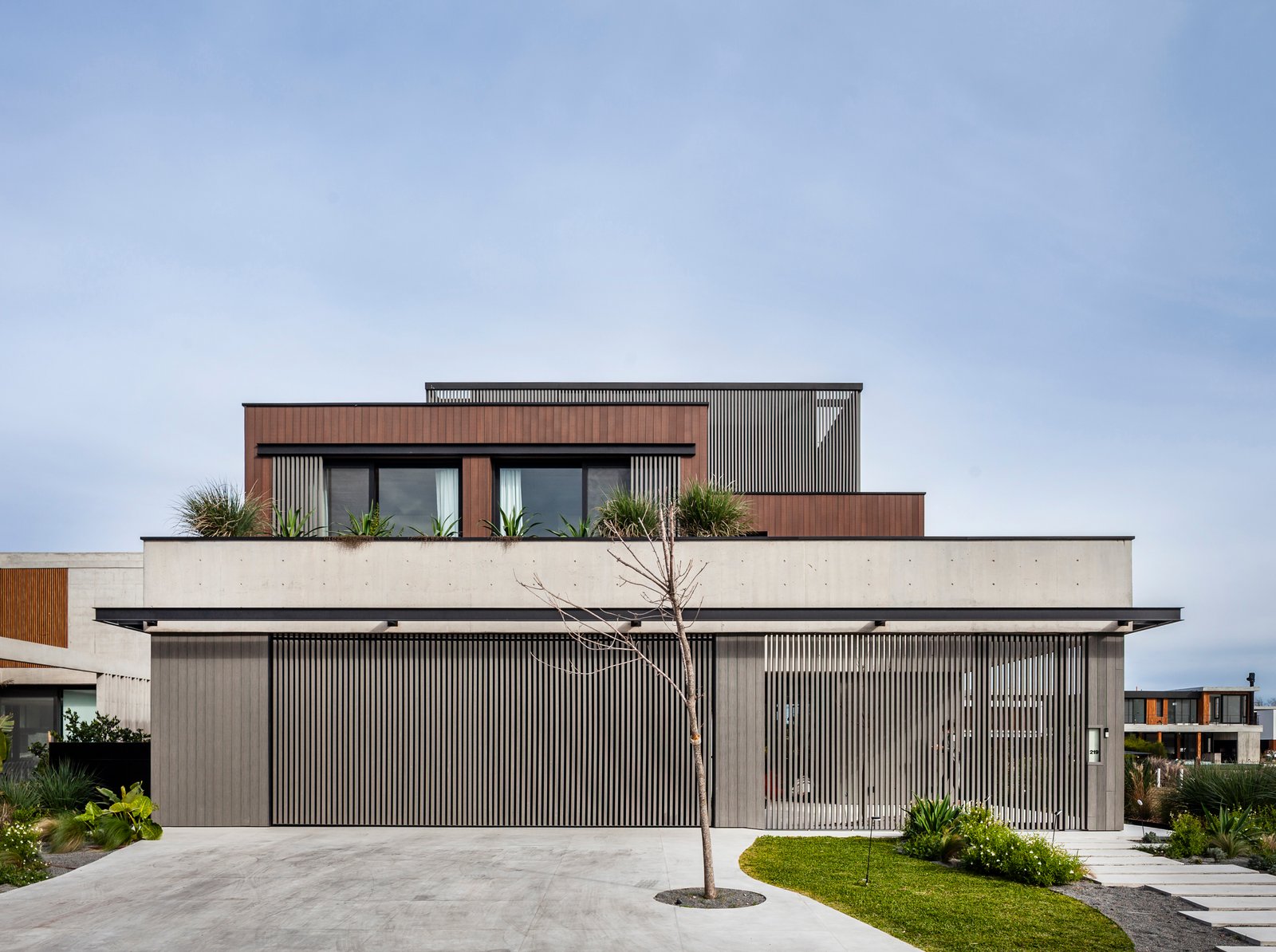fachada moderna minimalista con detalles en madera y cristal — proyecto Obra Warehouse, por lifecycle, en Nordelta