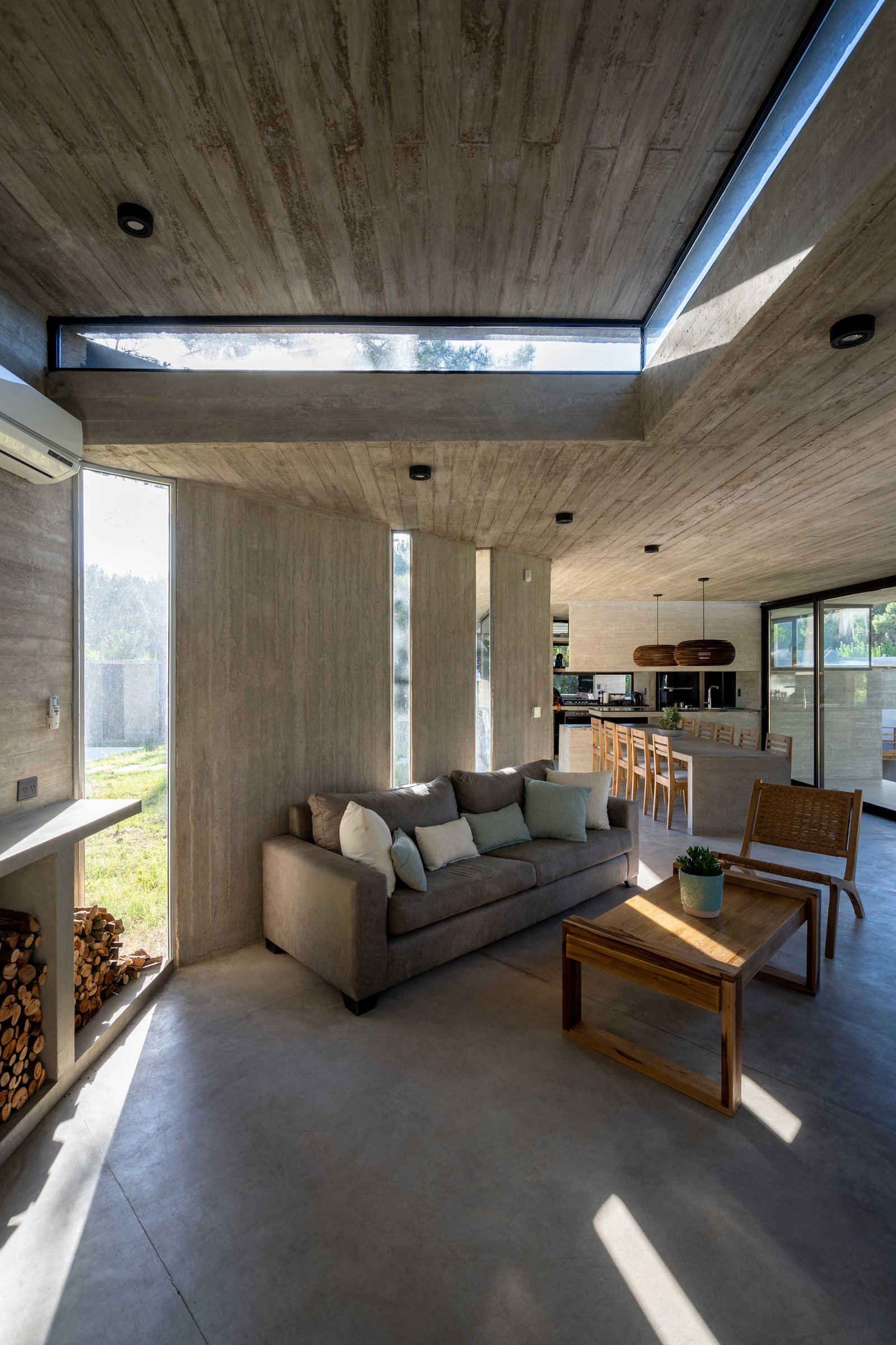 Living moderno brutalista con mucho hormigón y luz natural — proyecto Casa Senderos, por Besonías Almeida arquitectos, en X6VF+67