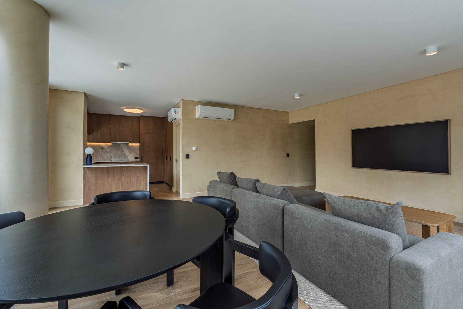 Living comedor moderno con paredes texturizadas y sofá modular gris — proyecto Godoy Cruz, por ABEJA CONCEPT, en Palermo