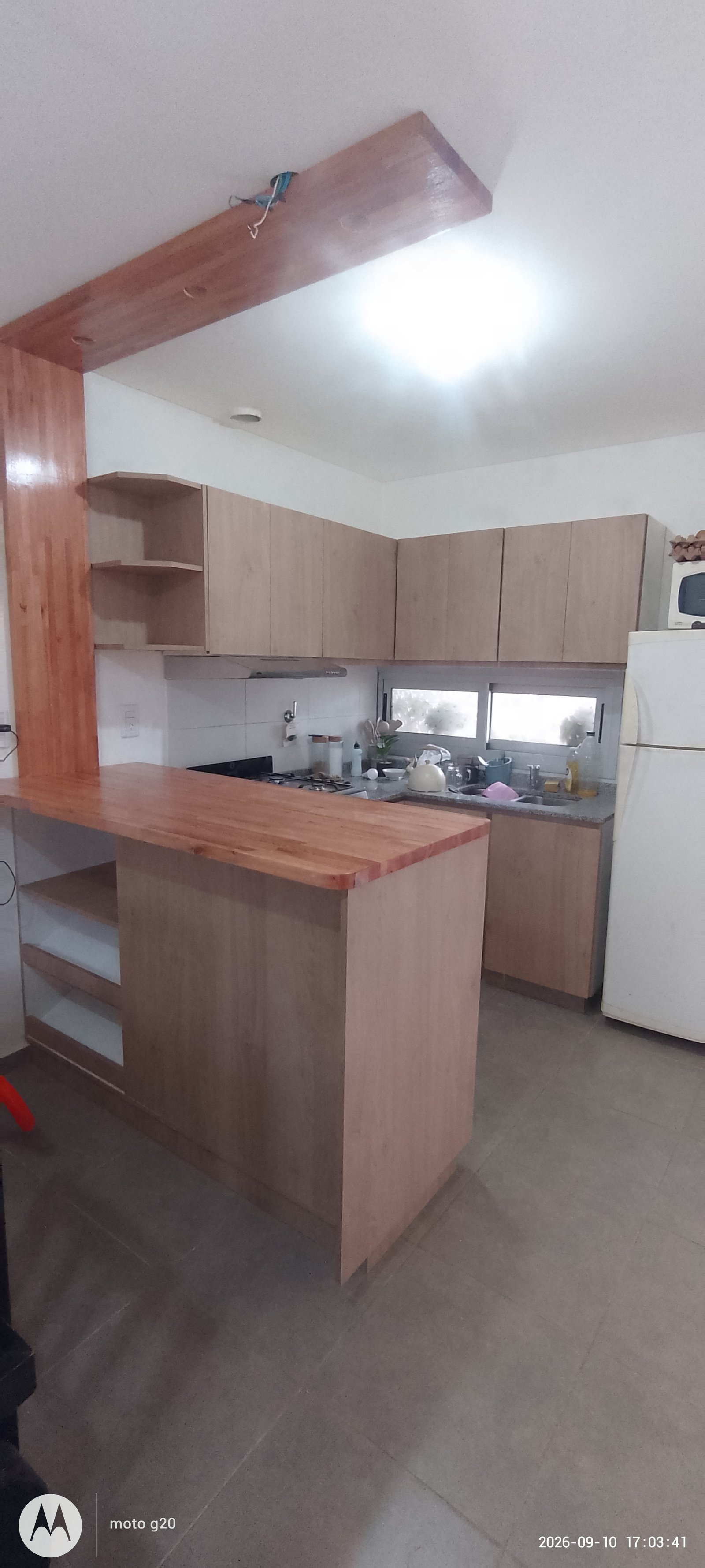 Cozinha moderna com ilha de madeira e armários claros — projeto Cocina minimalista, por Abrego Amoblamientos, em Urquiza
